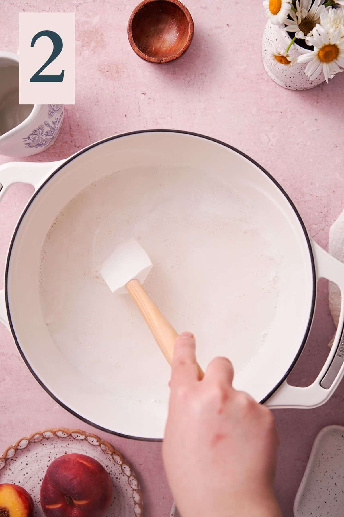 hand stirring brown sugar into milk in a dutch oven. 