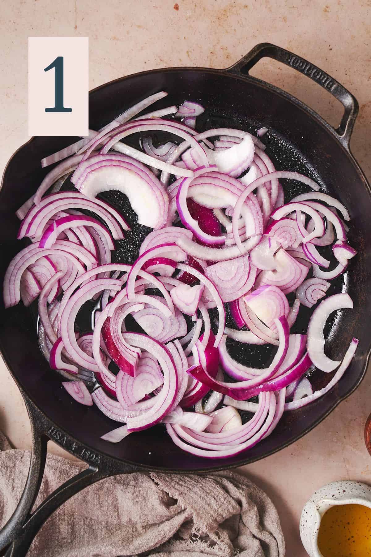 raw red onion strips in a cast iron skillet. 