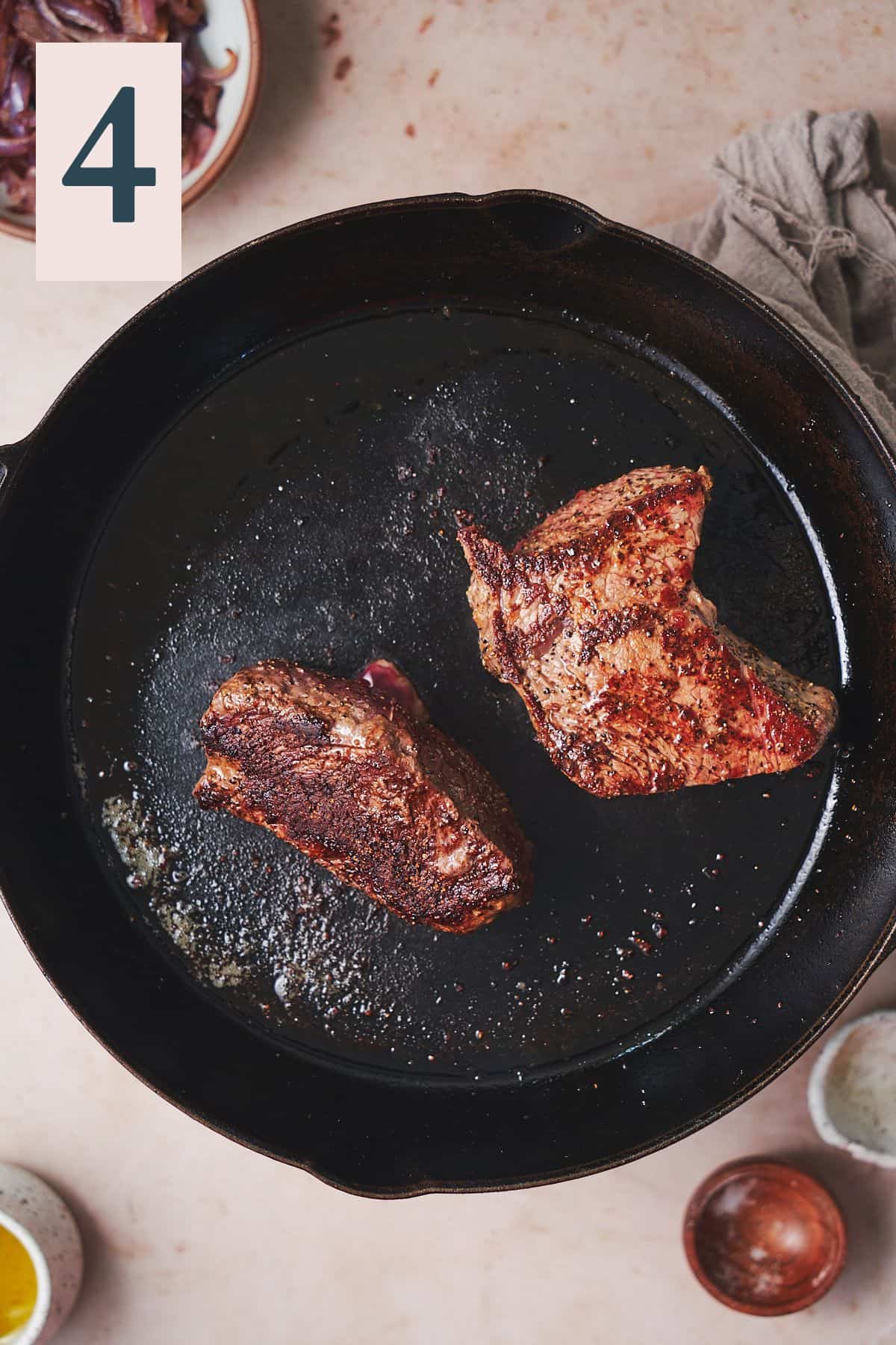 steaks cooked with a nice crust in a cast iron skillet. 