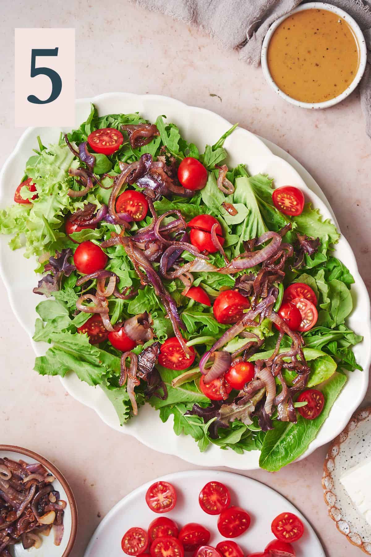 mixed greens layered with tomatoes and grilled red onions.