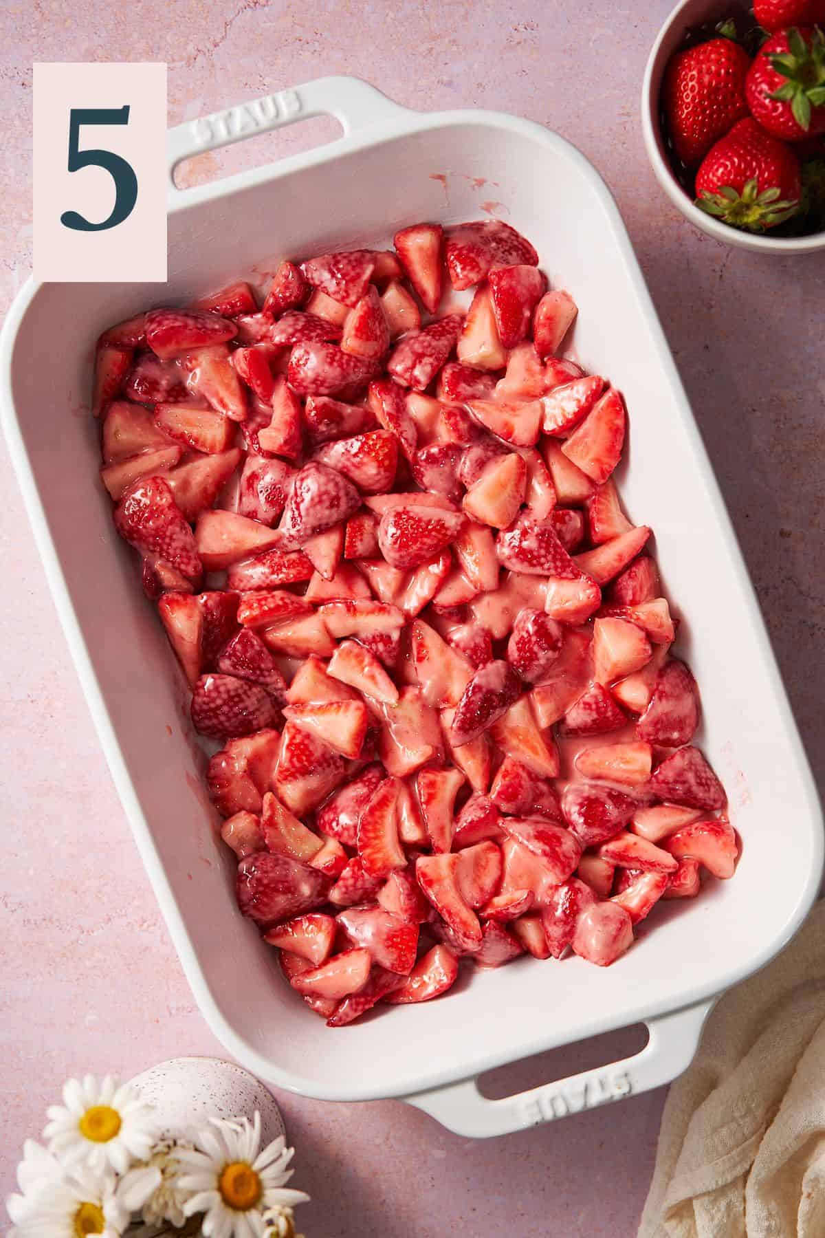 strawberries coated with flour and sugar in a large baking dish. 