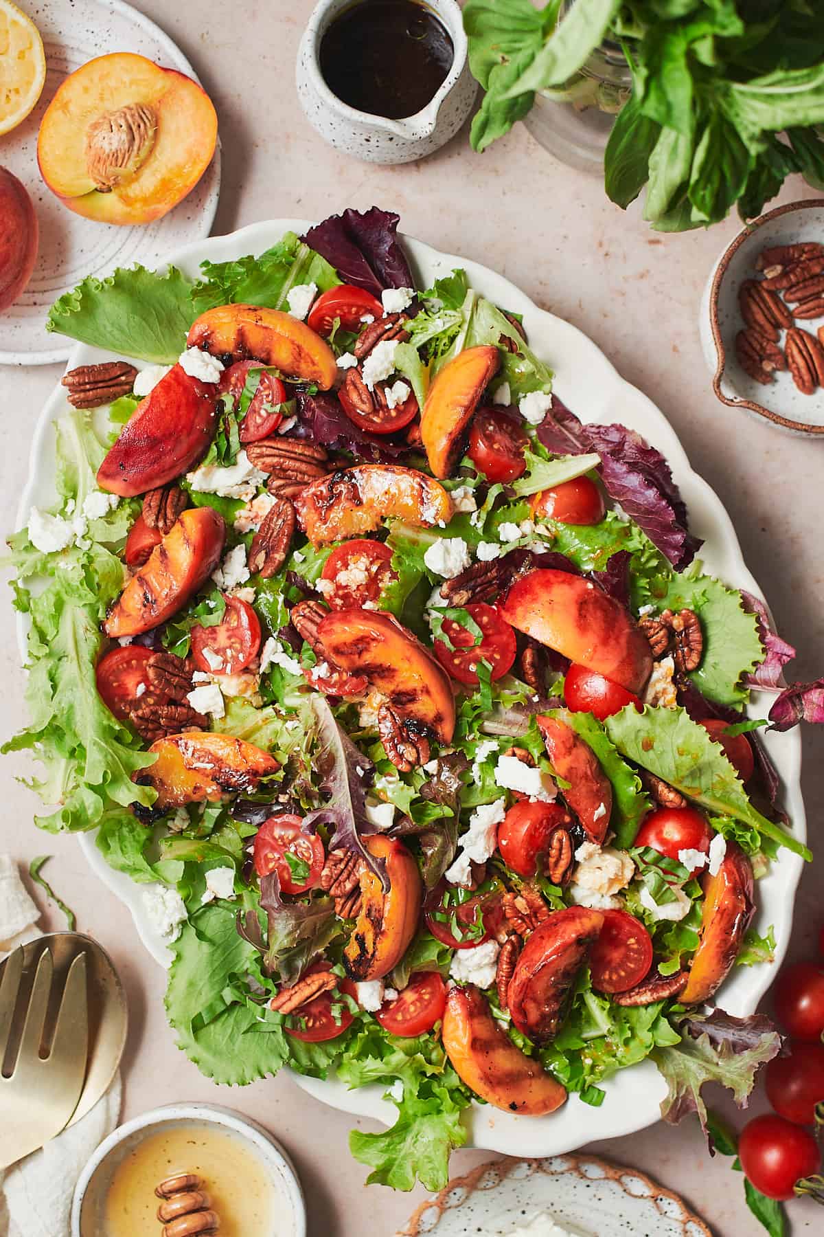 Grilled peach salad beautifully arranged with various ingredients on a serving plate.