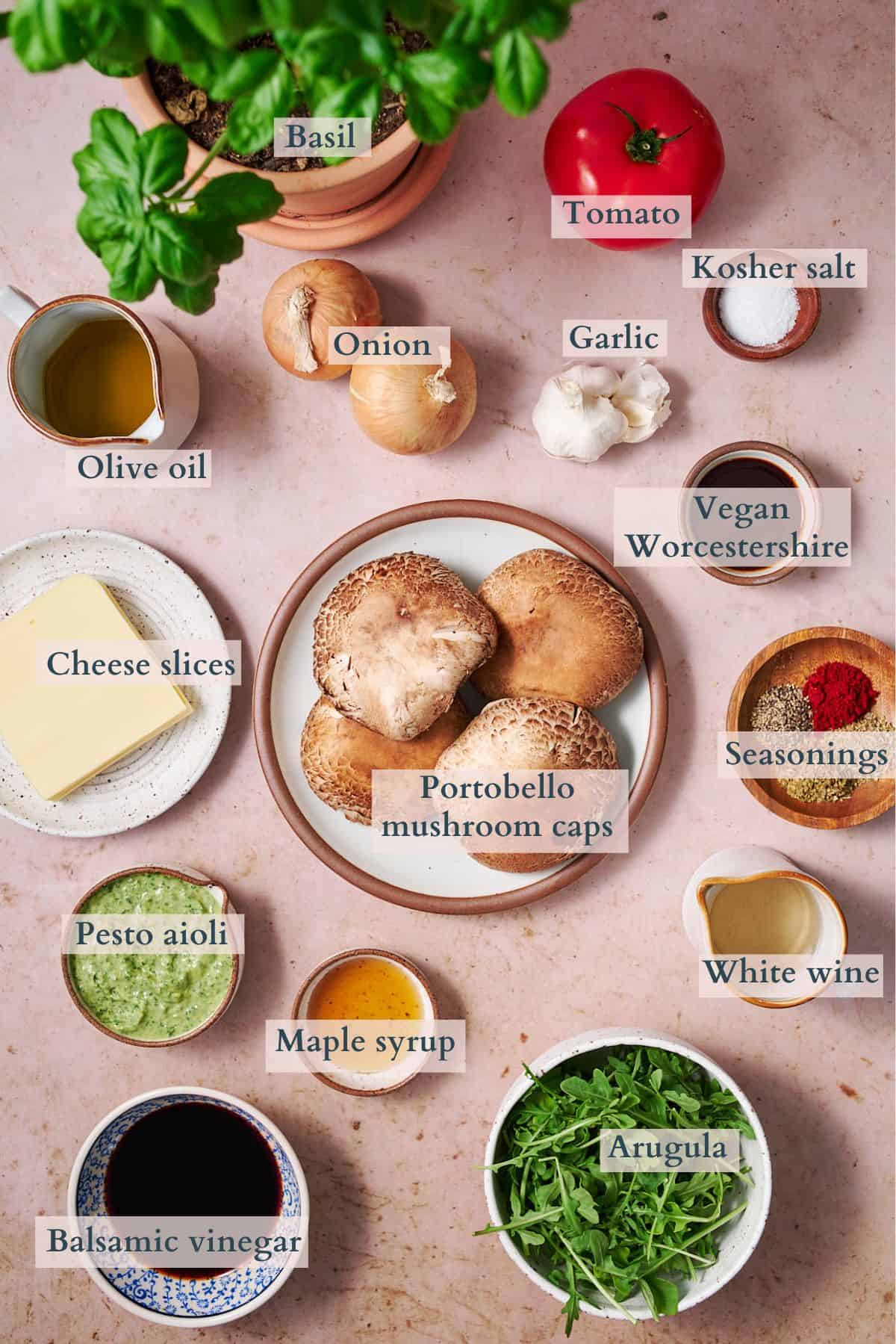 Ingredients to make a portobello mushroom burger laid out on small plates and in bowls and labeled to denote each ingredient. 