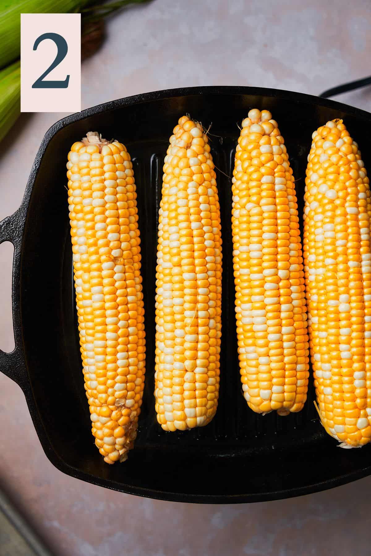 raw corn on a grill pan.