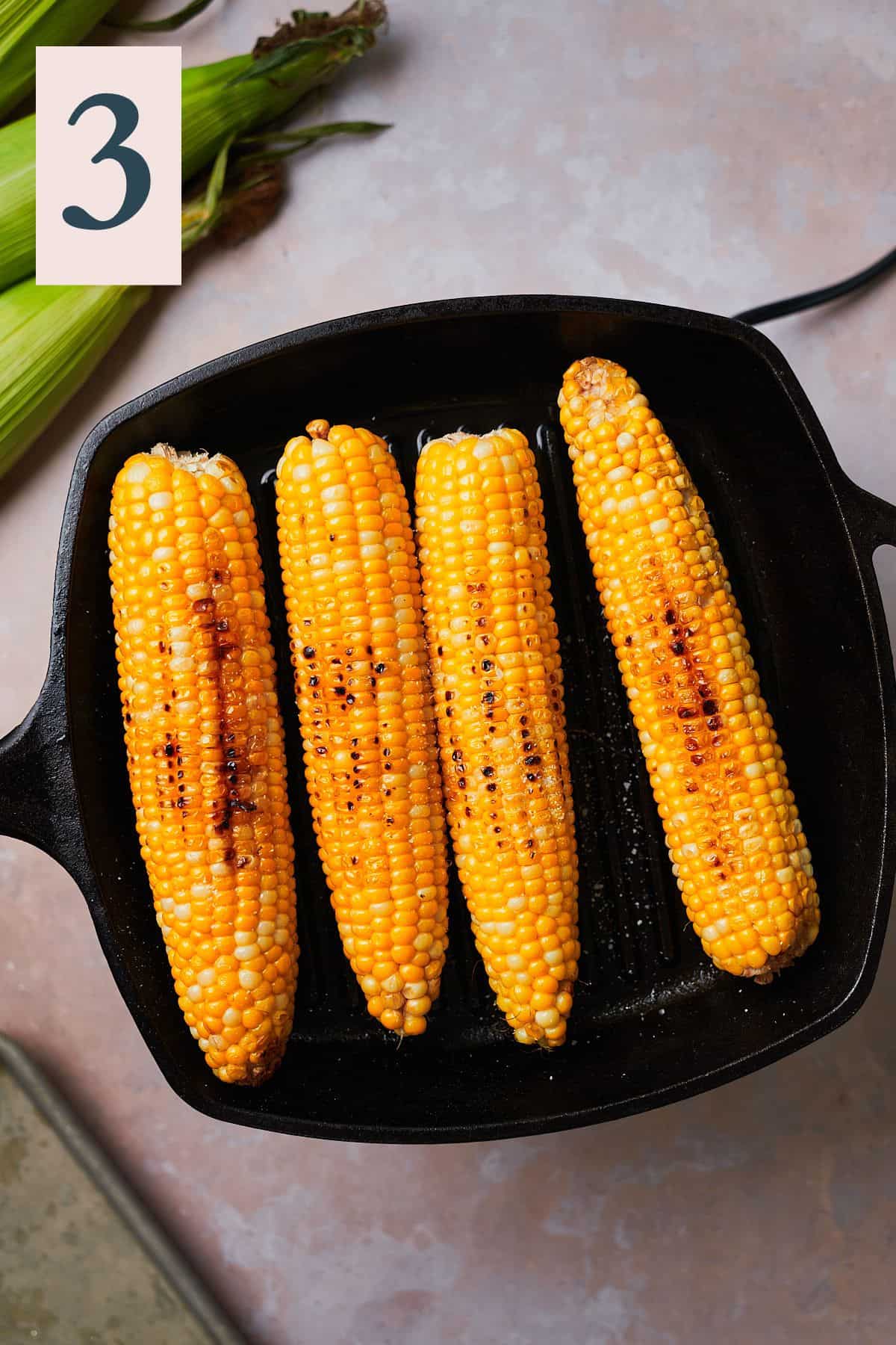 charred corn on the cob on a grill pan. 