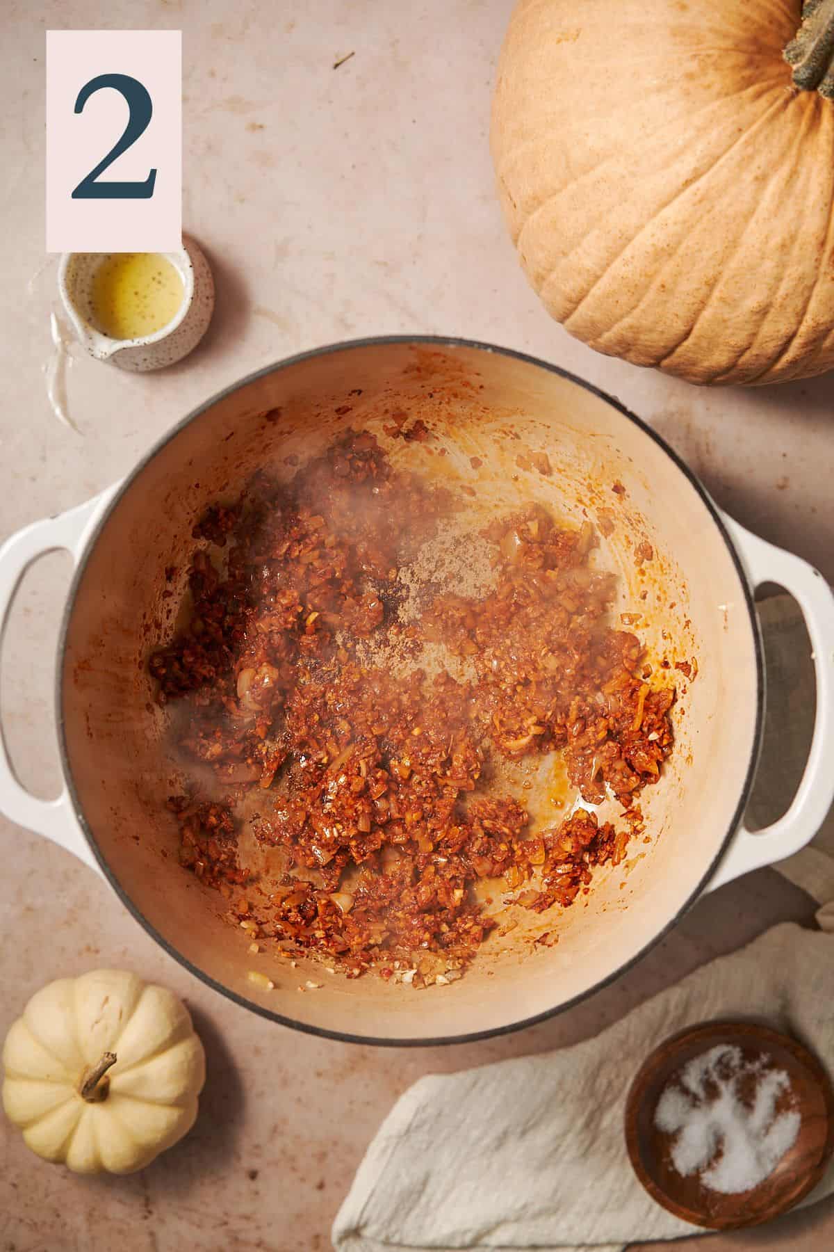 Cooked onions and aromatics with tomato sauce in a dutch oven. 