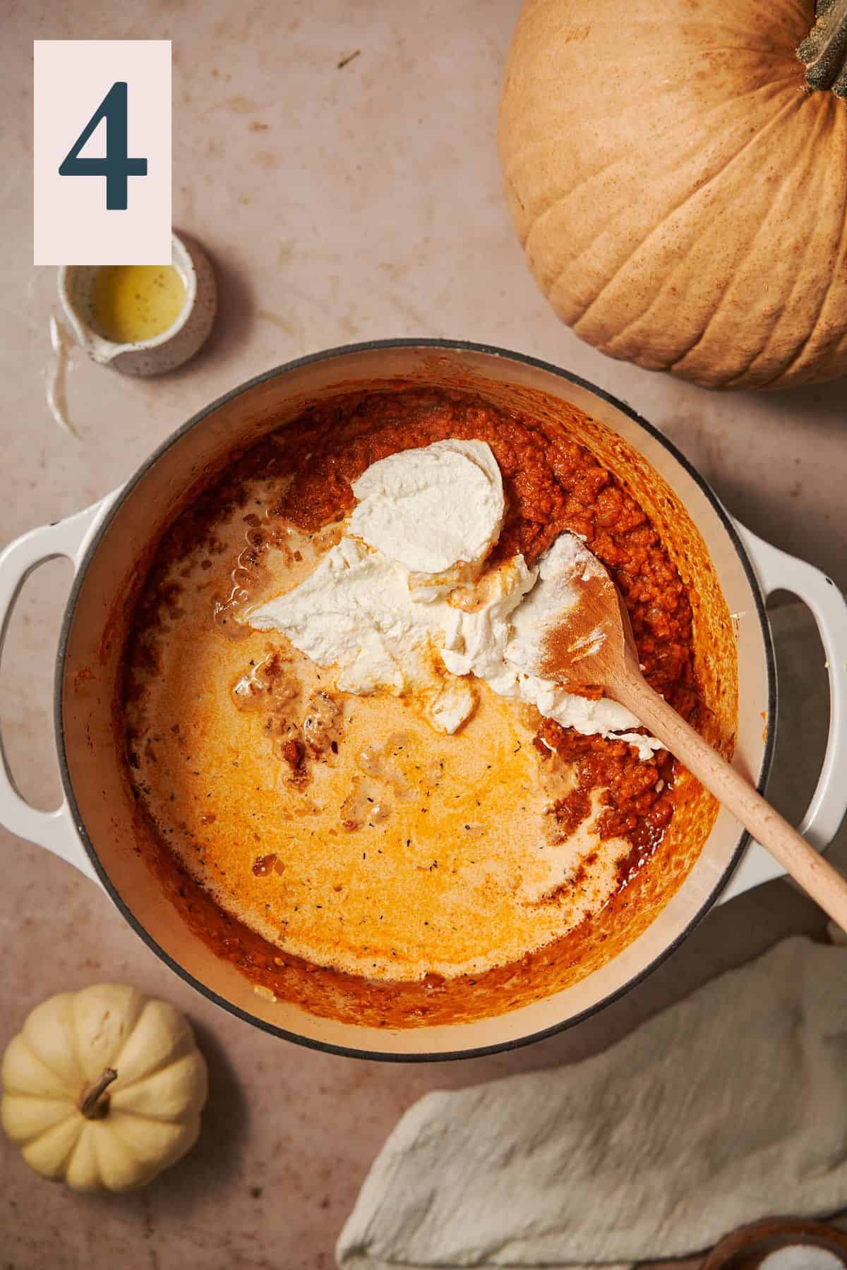 pumpkin sauce with cream and ricotta cheese added to it in a dutch oven. 