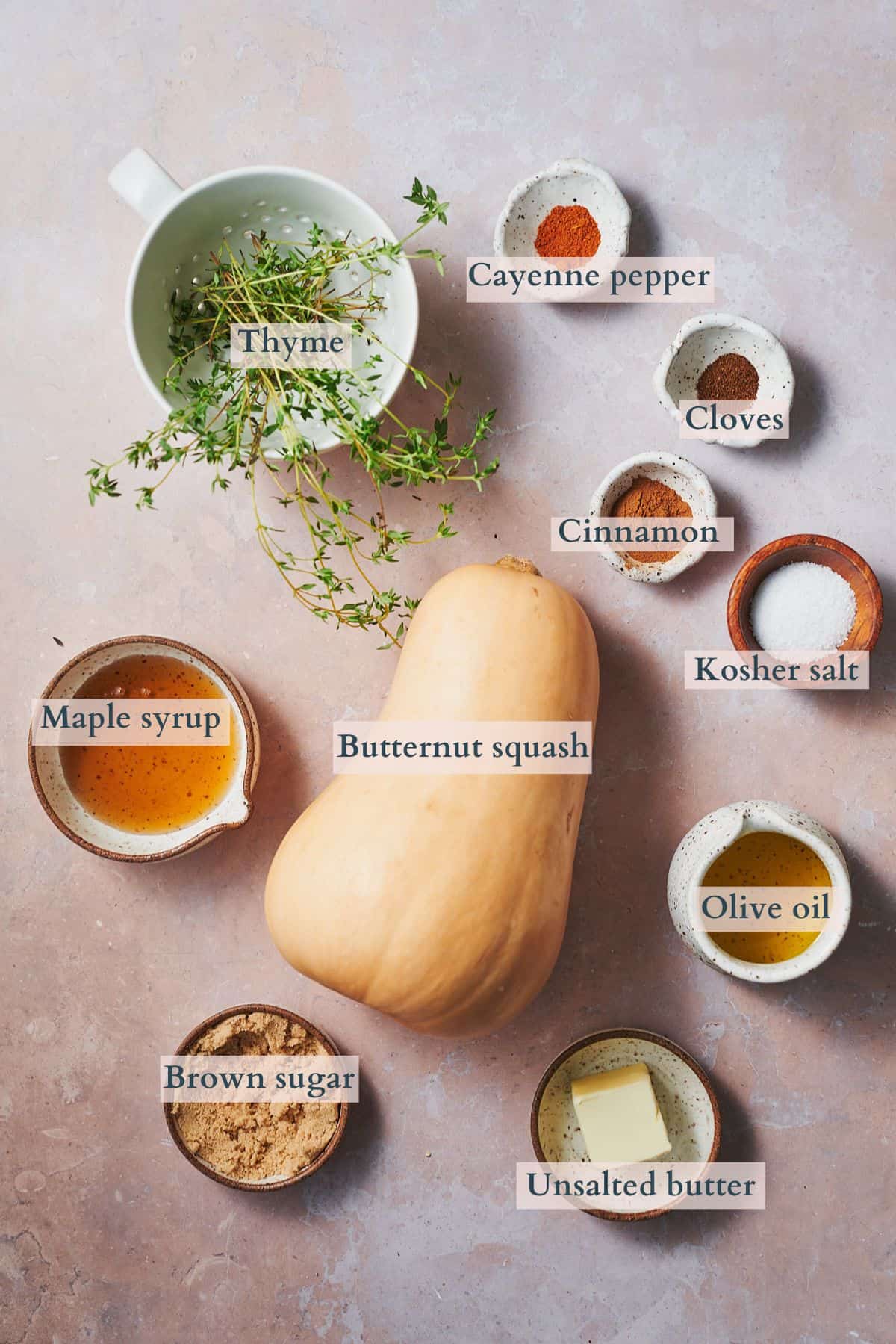 Ingredients to make roasted butternut squash with brown sugar laid out on a table and labeled to denote each ingredient.