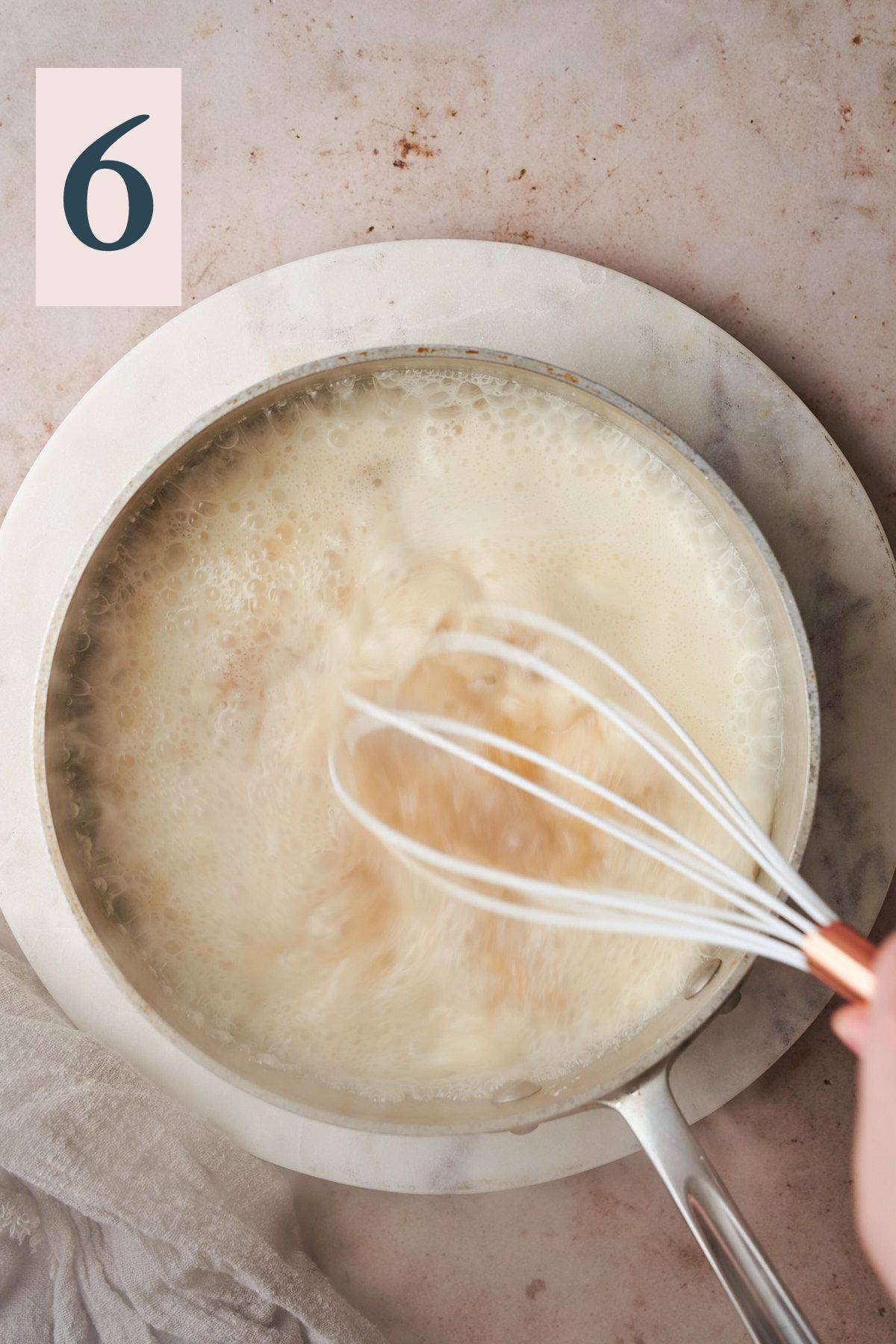 hand whisking together cream quickly with water. 
