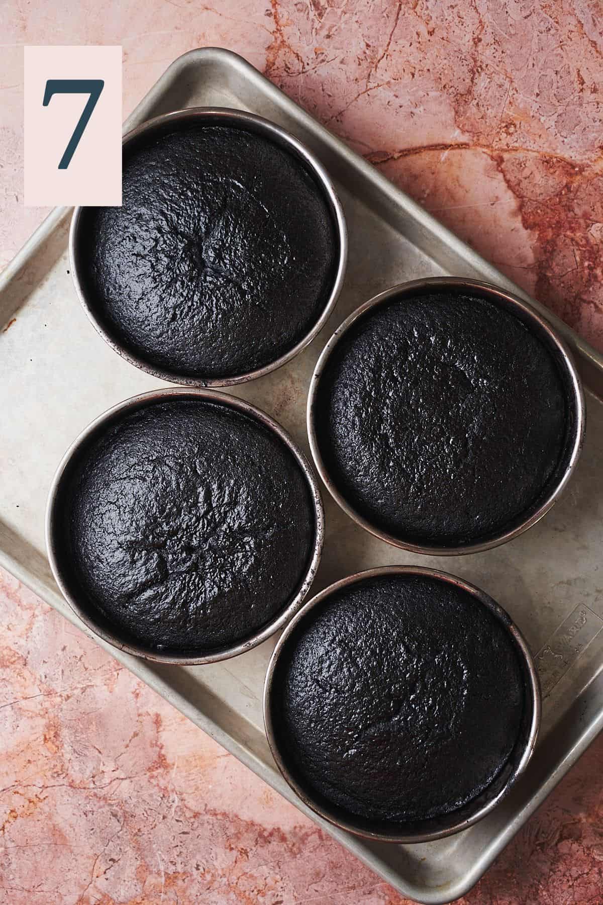 baked dark chocolate cake layers in cake tins. 