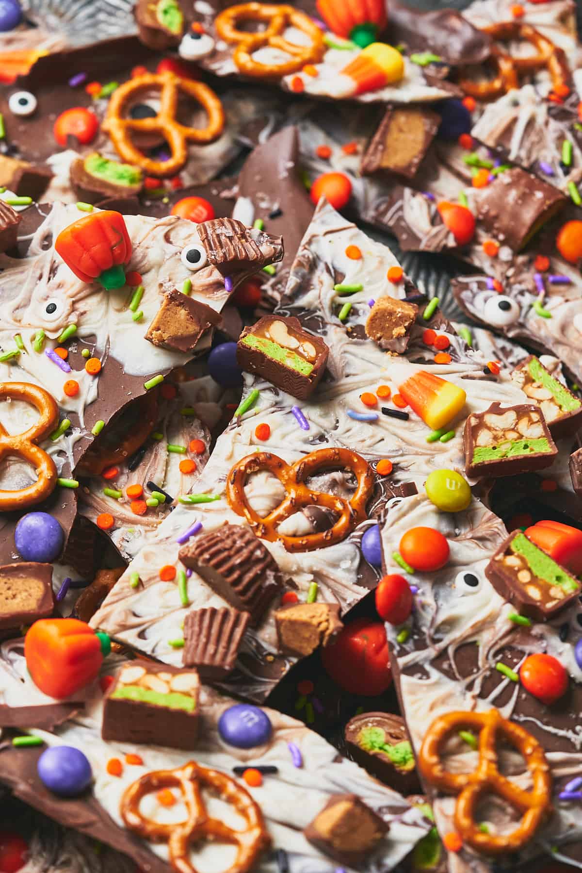 Close up shot of Halloween chocolate bark with tons of candy, sprinkles, pretzels and candy eyeballs. 