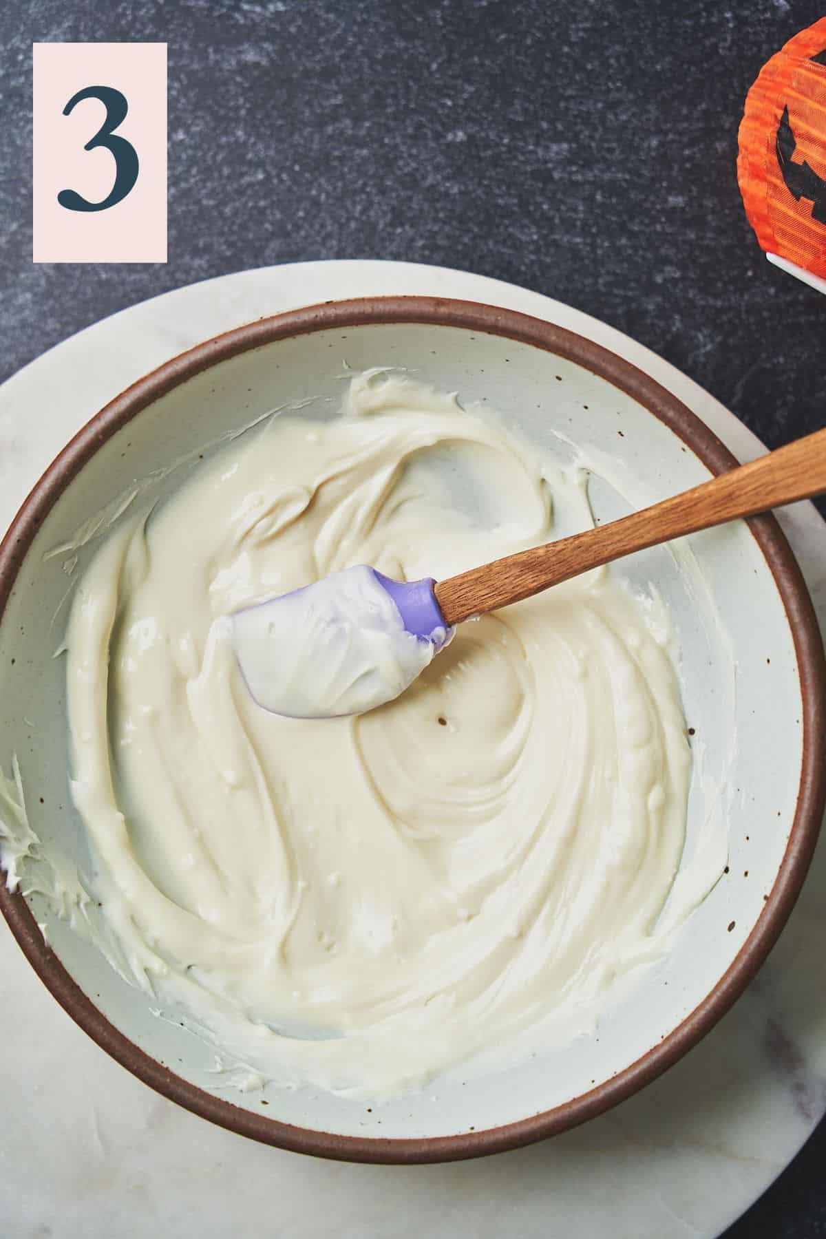 melted white chocolate in a large mixing bowl with a rubber spatula. 