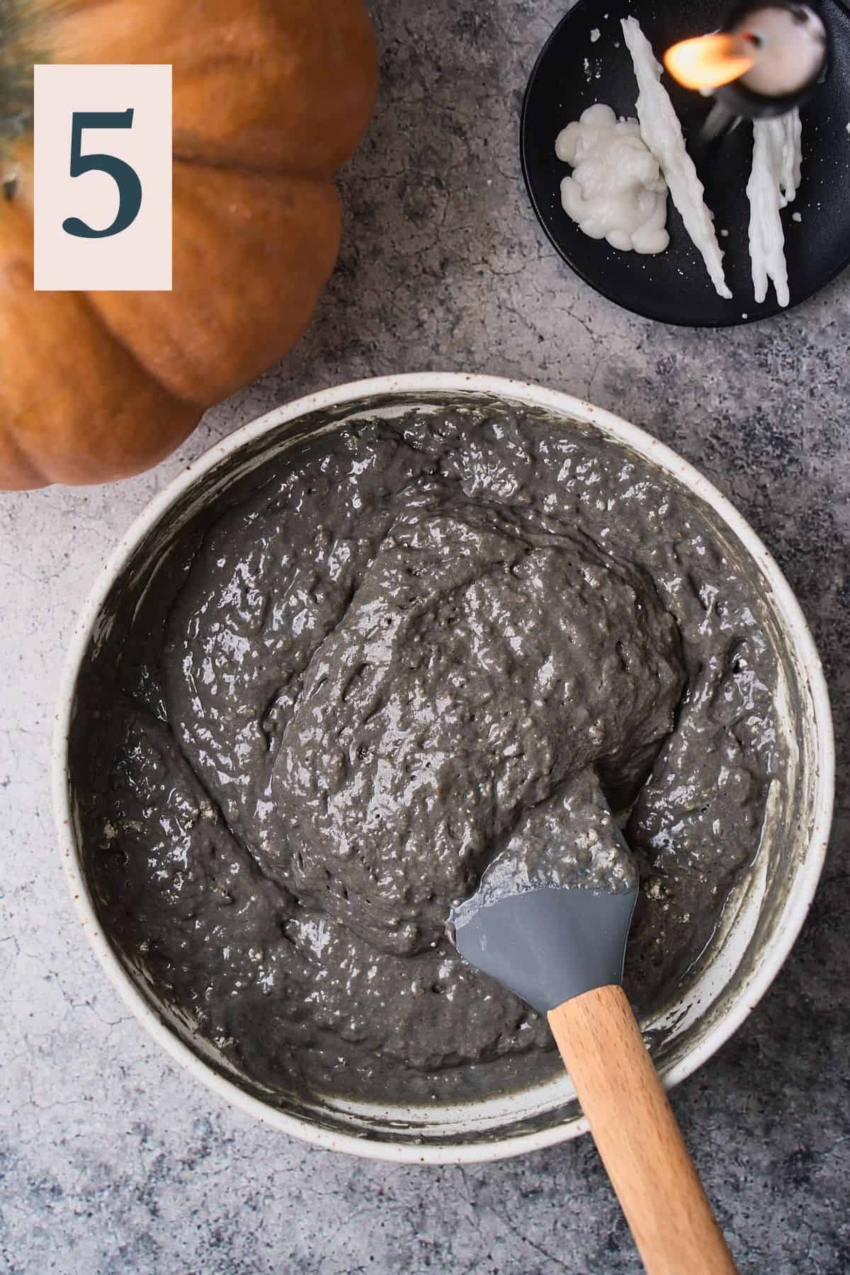 black pancake batter in a bowl with a rubber spatula. 