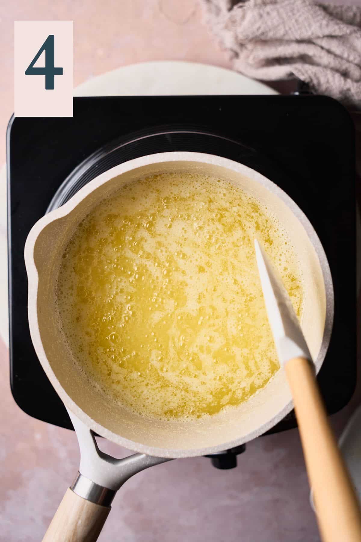 milk solids separating from melted butter in a saucepan.