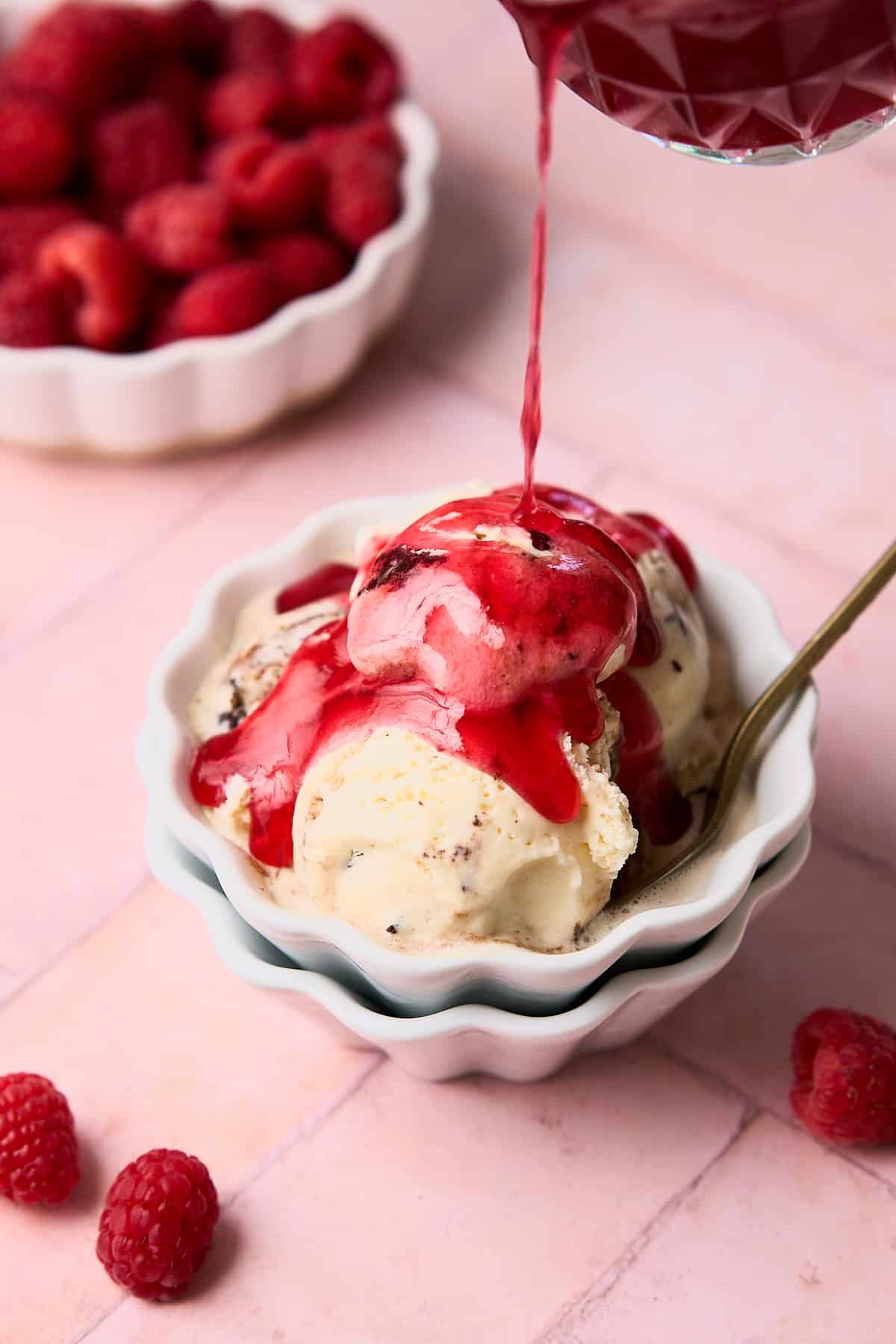 Raspberry syrup poured on top of vanilla ice cream.