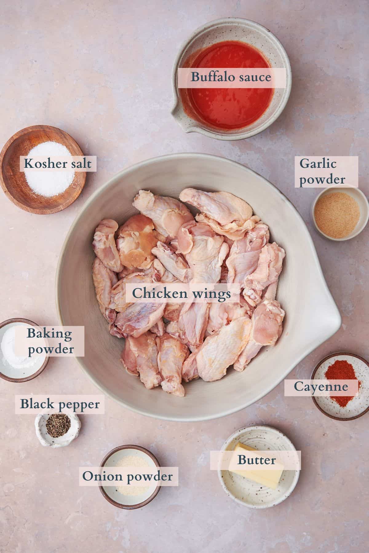 Ingredients to make baked buffalo wings on a warm backdrop.