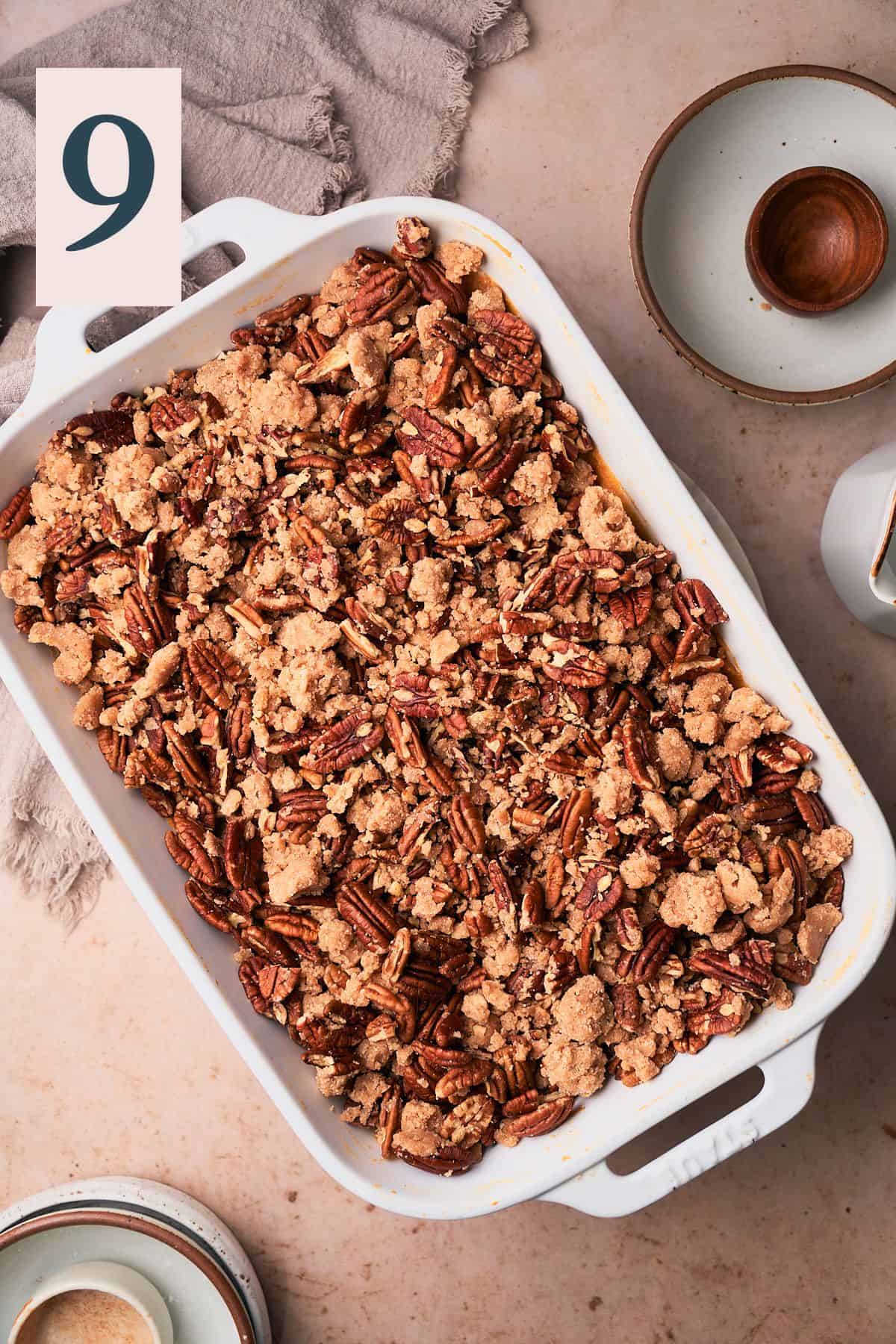 pecan streusel topping added to the top of the sweet potato mixture in a baking dish. 