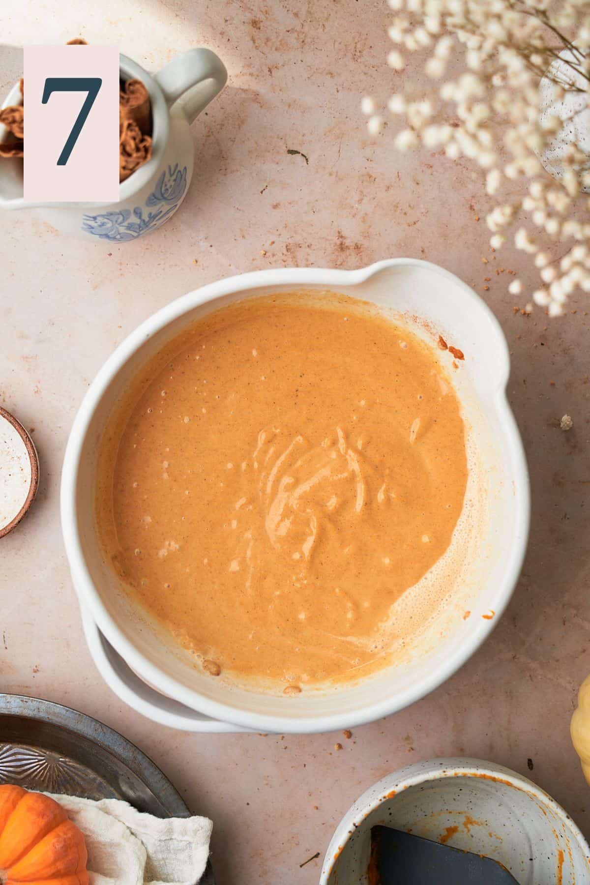 combined pumpkin puree, sugar, spices, and cream mixture in a mixing bowl. 