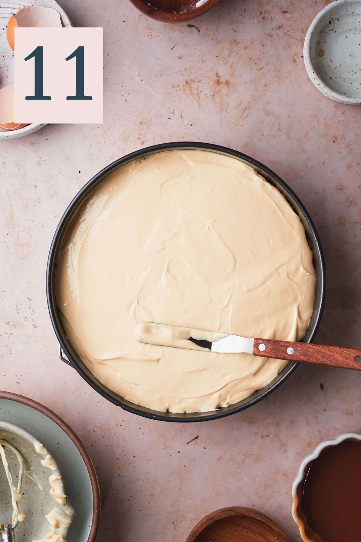spreading a cheesecake in a springform pan with an offset spatula.