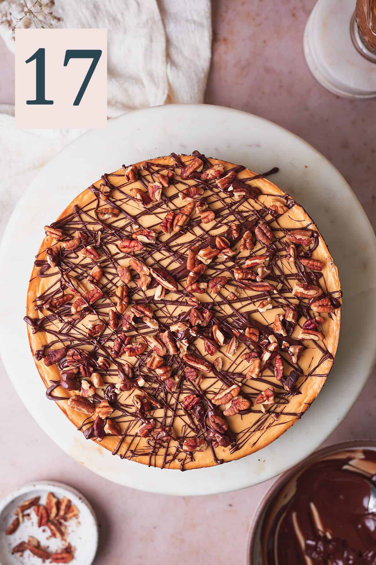 cheesecake topped with chocolate and pecan pieces. 