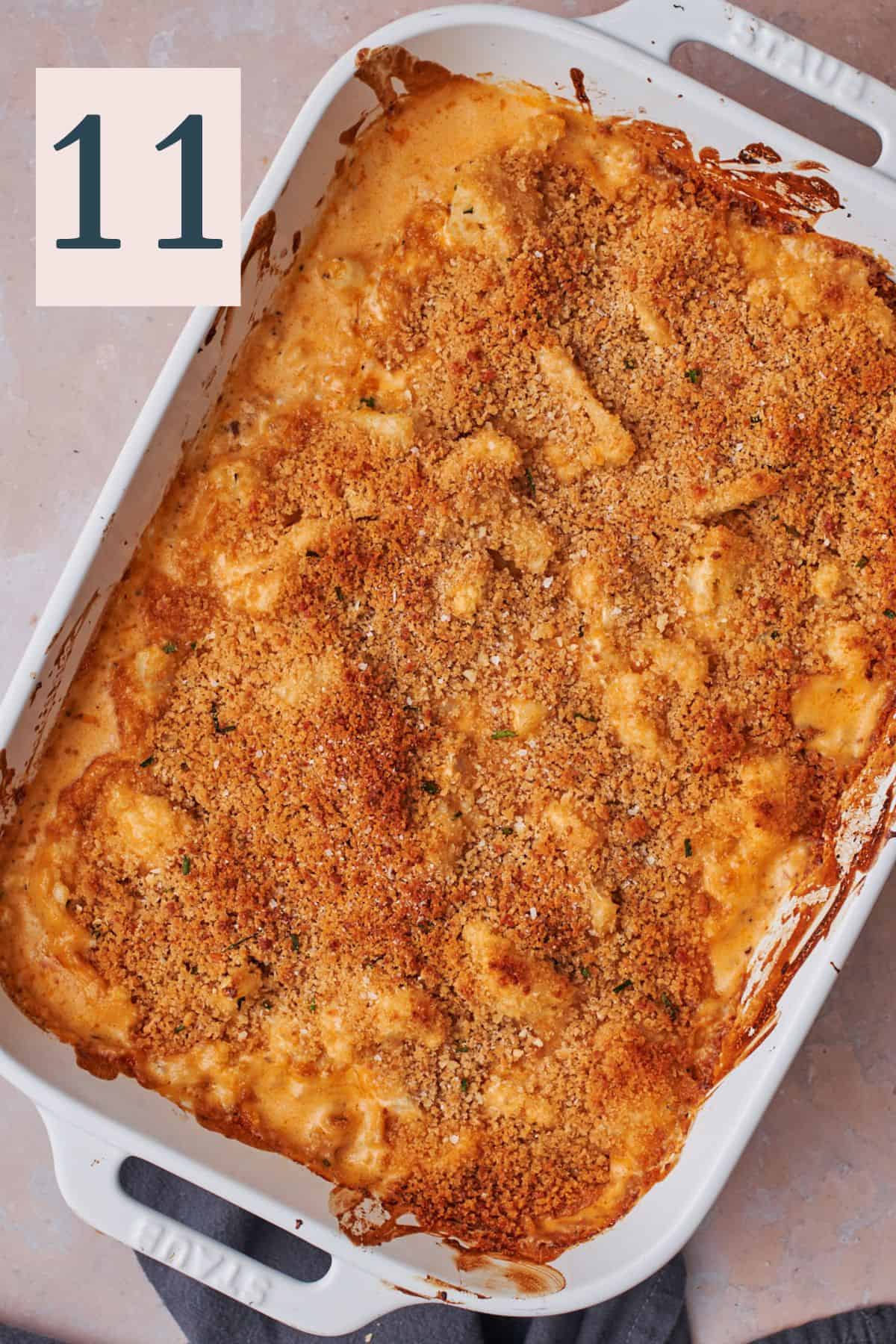 baked cheesy cauliflower with breadcrumbs on top in a casserole dish. 