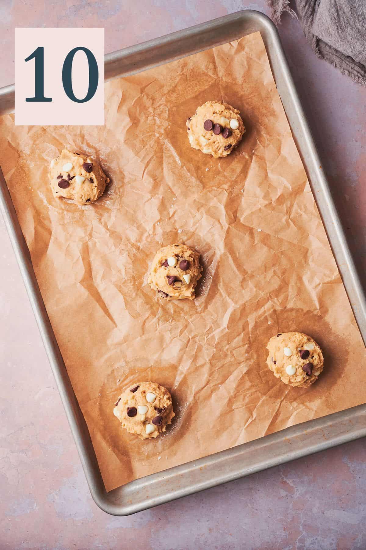 cookie dough balls on a cookie sheet. 