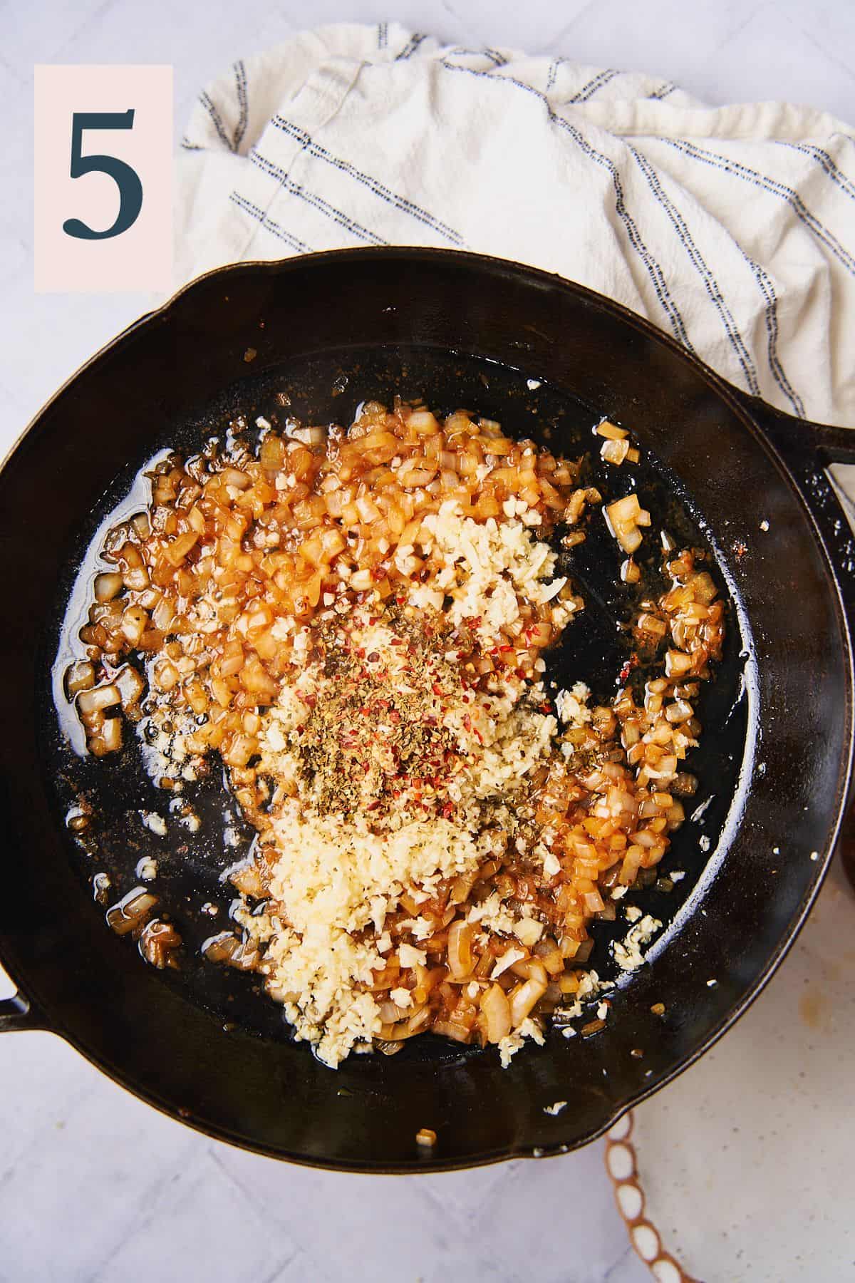 cooked onion in a skillet with garlic and seasonings added. 