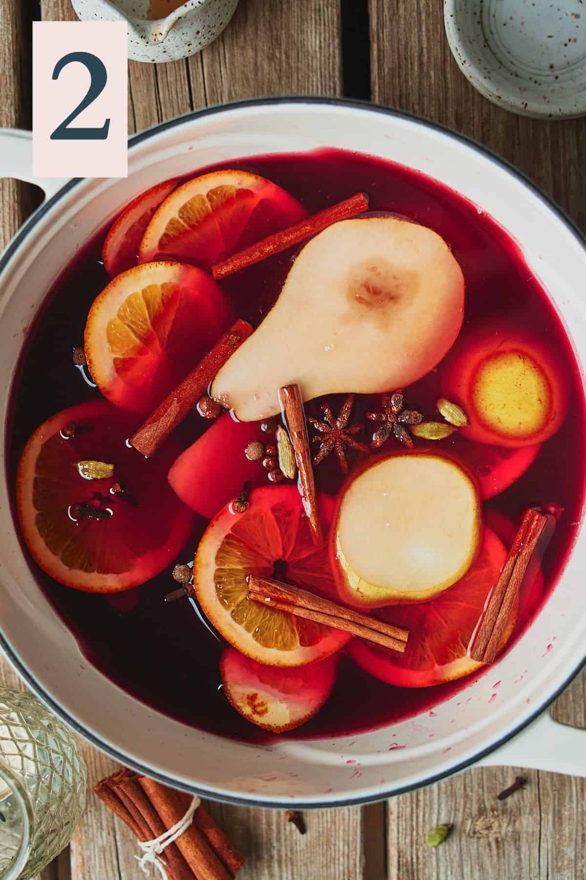orange slices, pears, cinnamon sticks and whole mulling spices in a dutch oven with red wine. 