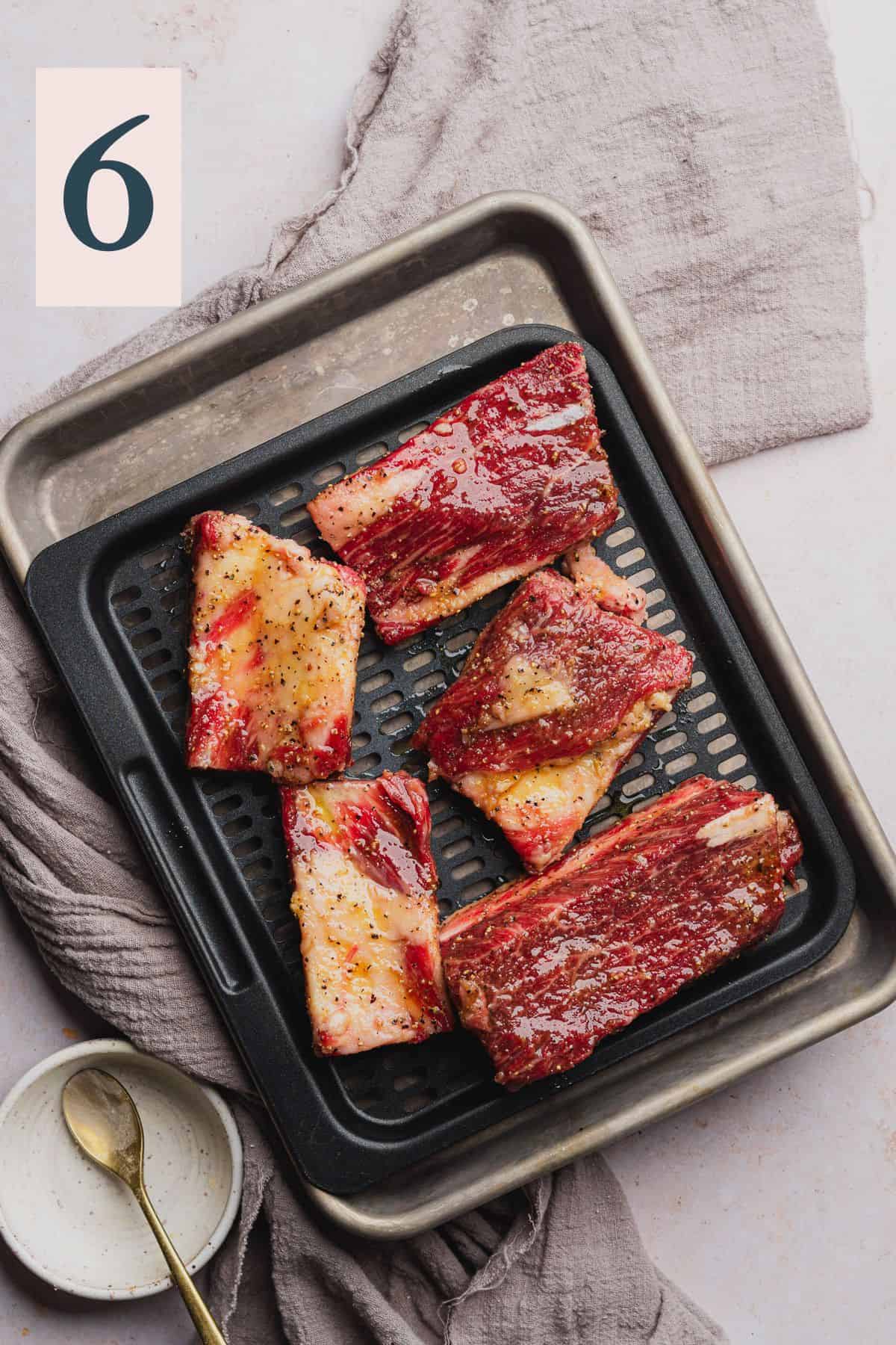 beef short ribs in a single layer on an air fryer tray