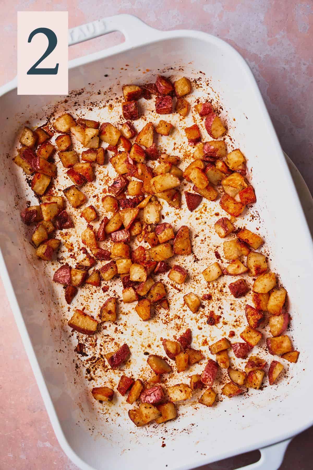 Crispy and golden brown potatoes in a white baking dish. 
