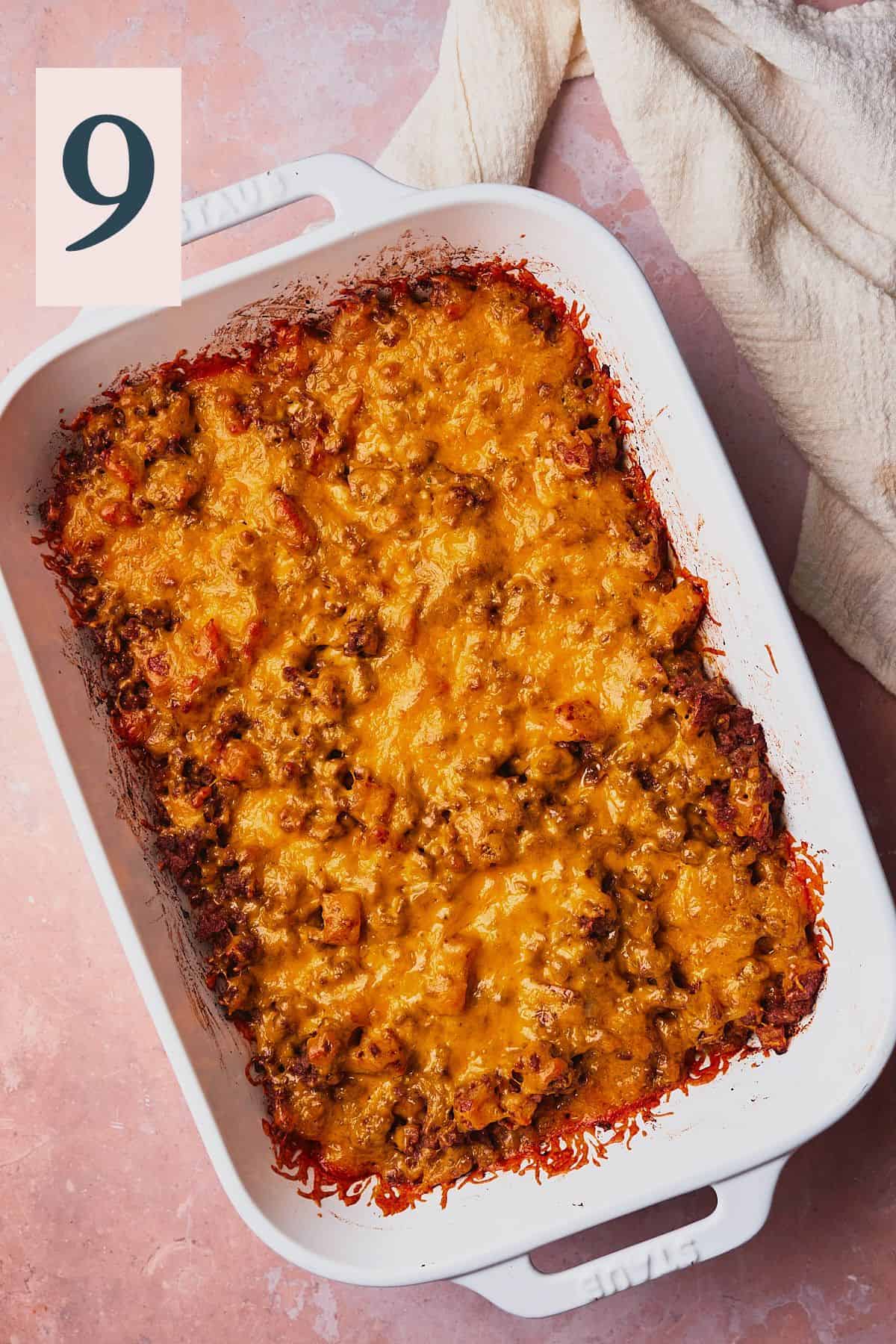 Baked and golden brown cheese on top of ground beef in a casserole dish. 