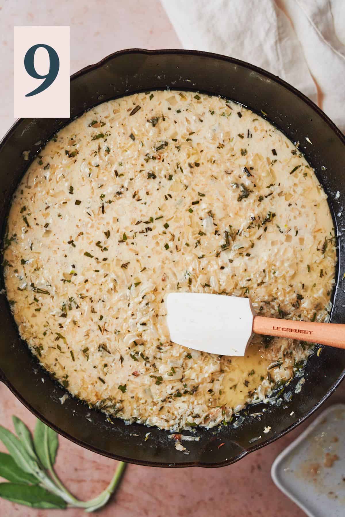 Creamy pan sauce with herbs, onion, and garlic in a skillet. 