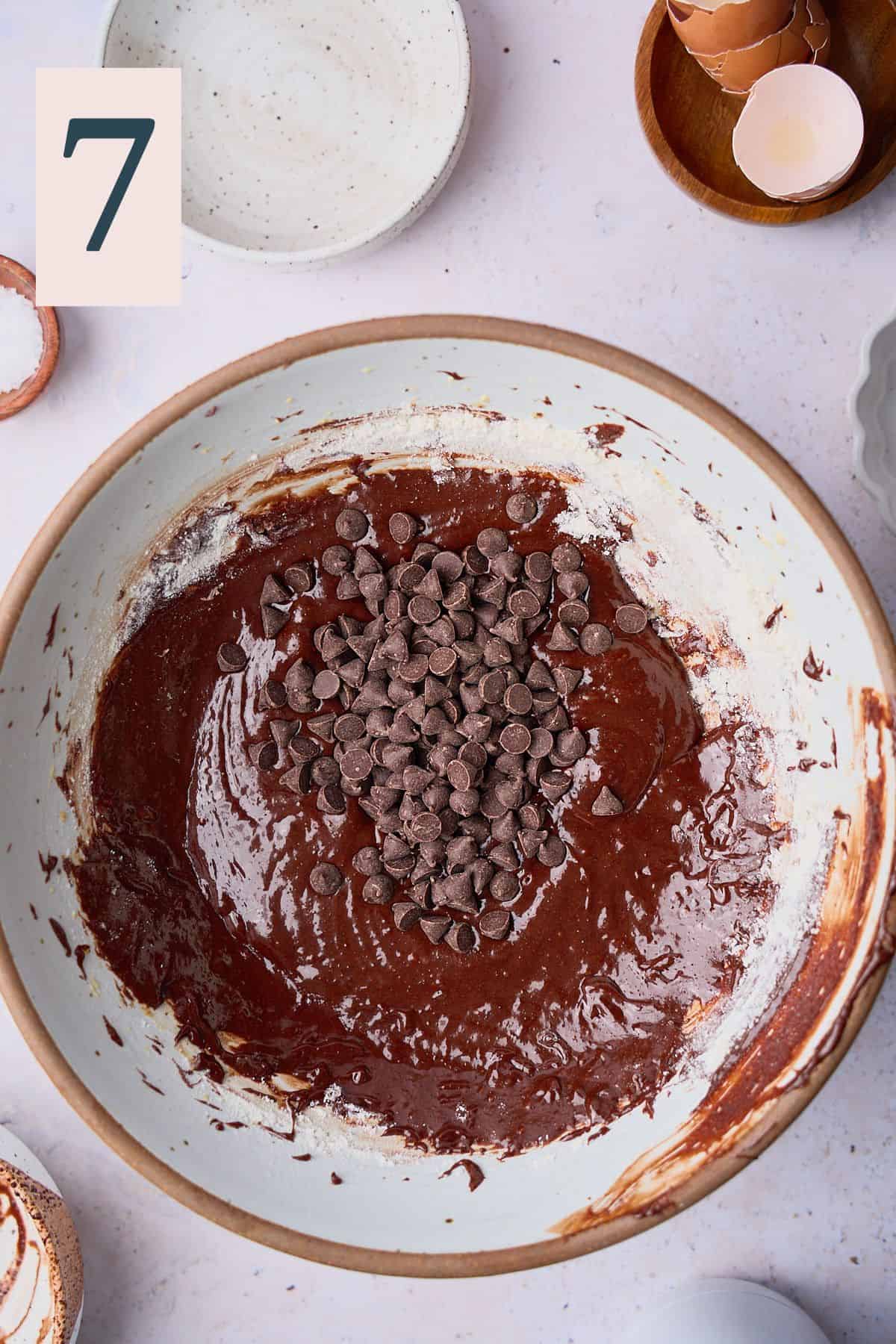 Mostly mixed brownie batter in a large bowl with chocolate chips added. 