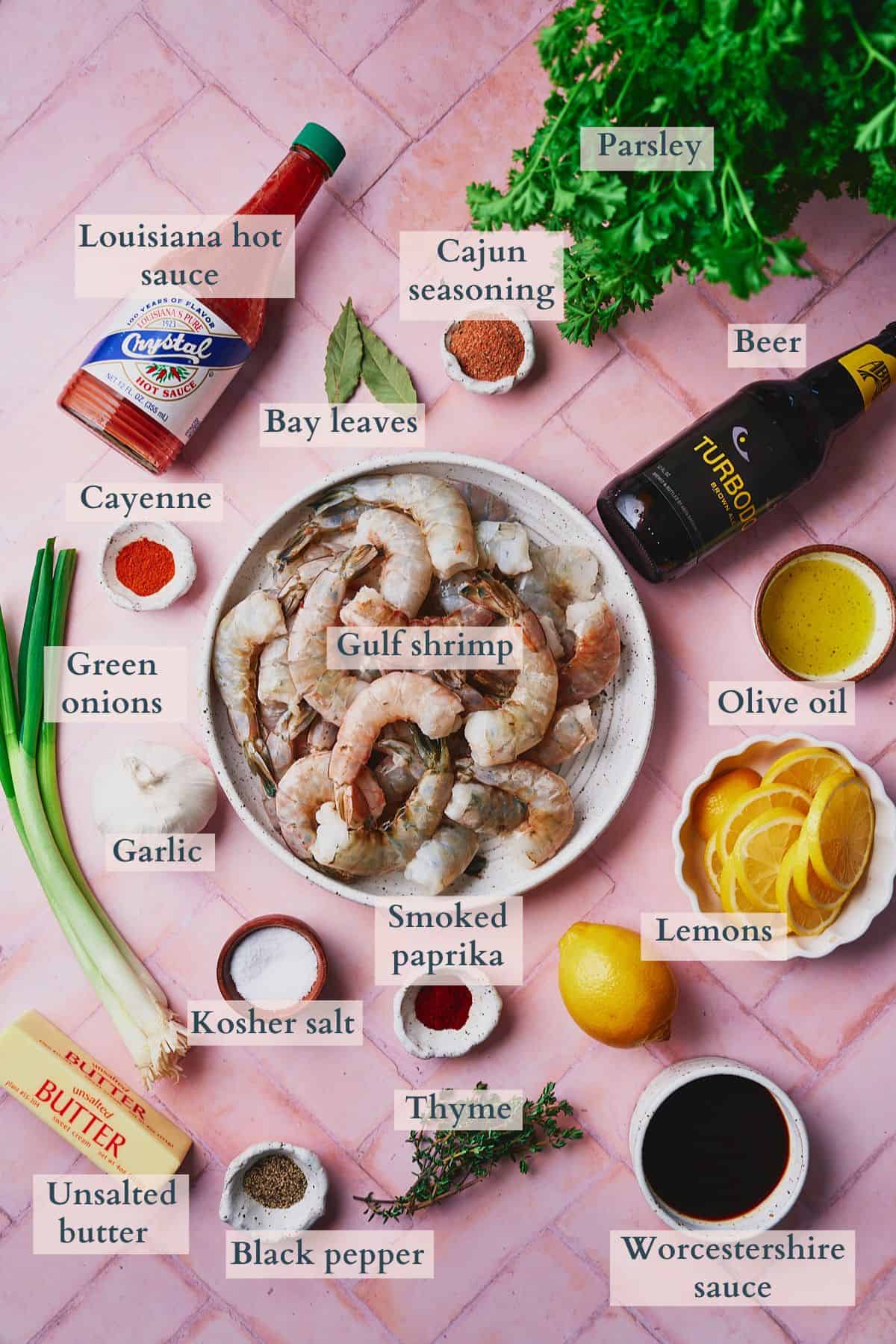 Ingredients to make new orleans bbq shrimp laid out on a table in small dishes and labeled to denote each ingredient. 