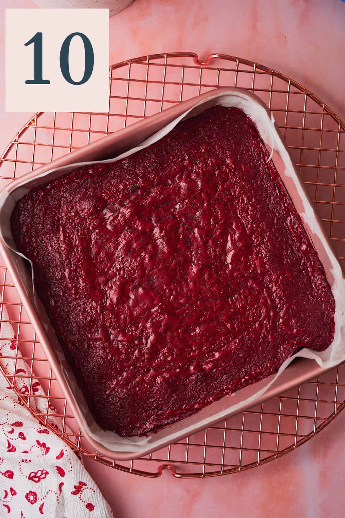 Baked red velvet brownies in a square baking pan on a cooling rack. 