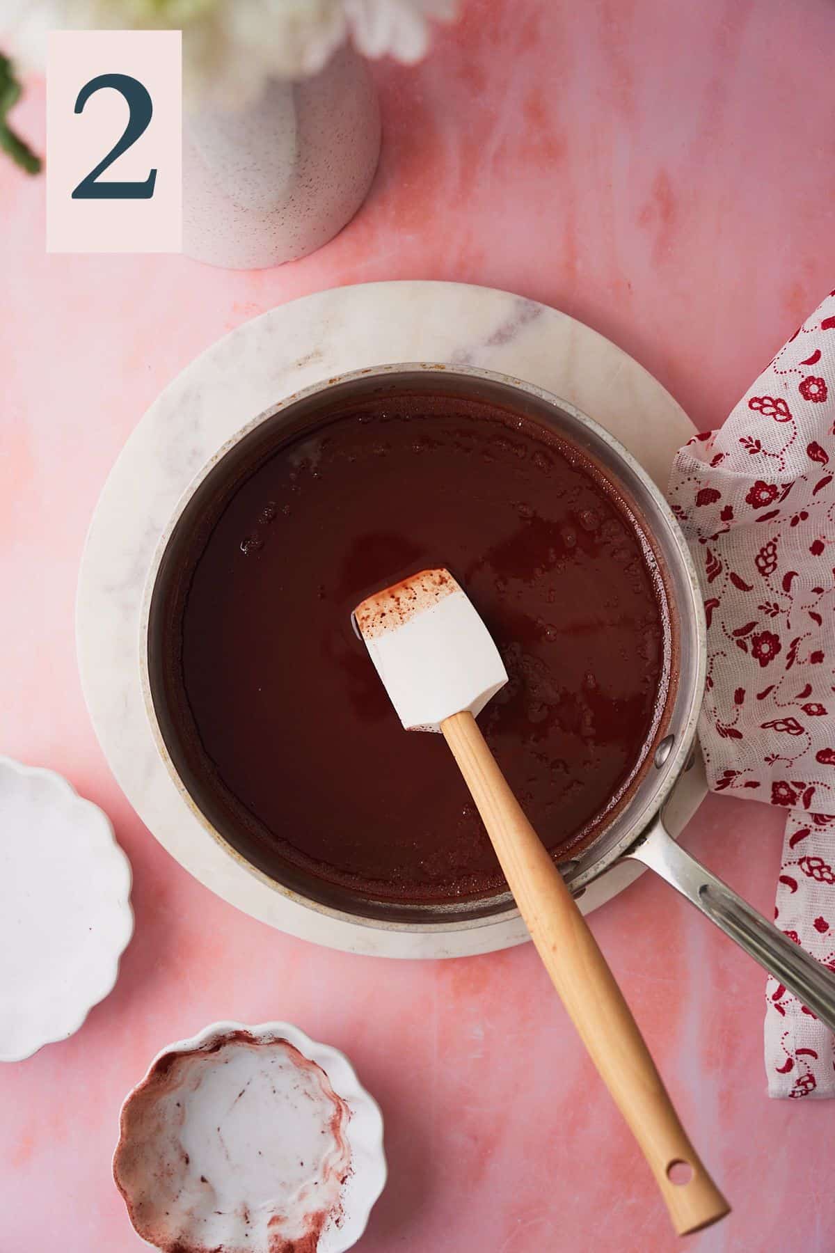 Rubber spatula in a saucepan with melted butter and chocolate to make a smooth mixture. 