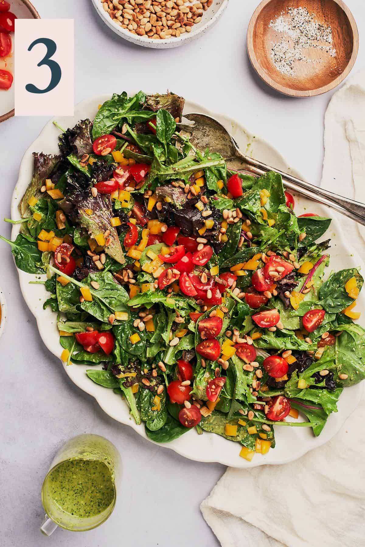 leafy greens topped with fresh chopped tomatoes, yellow bell pepper, and pine nuts.
