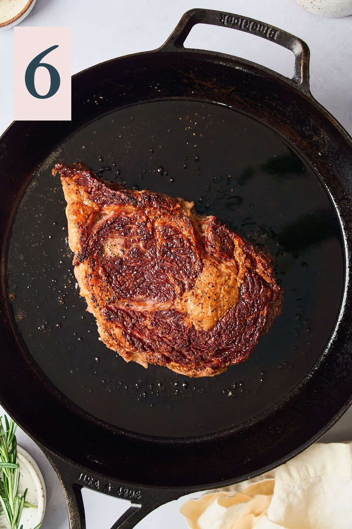 Ribeye steak in a cast iron pan with a wonderful sear. 
