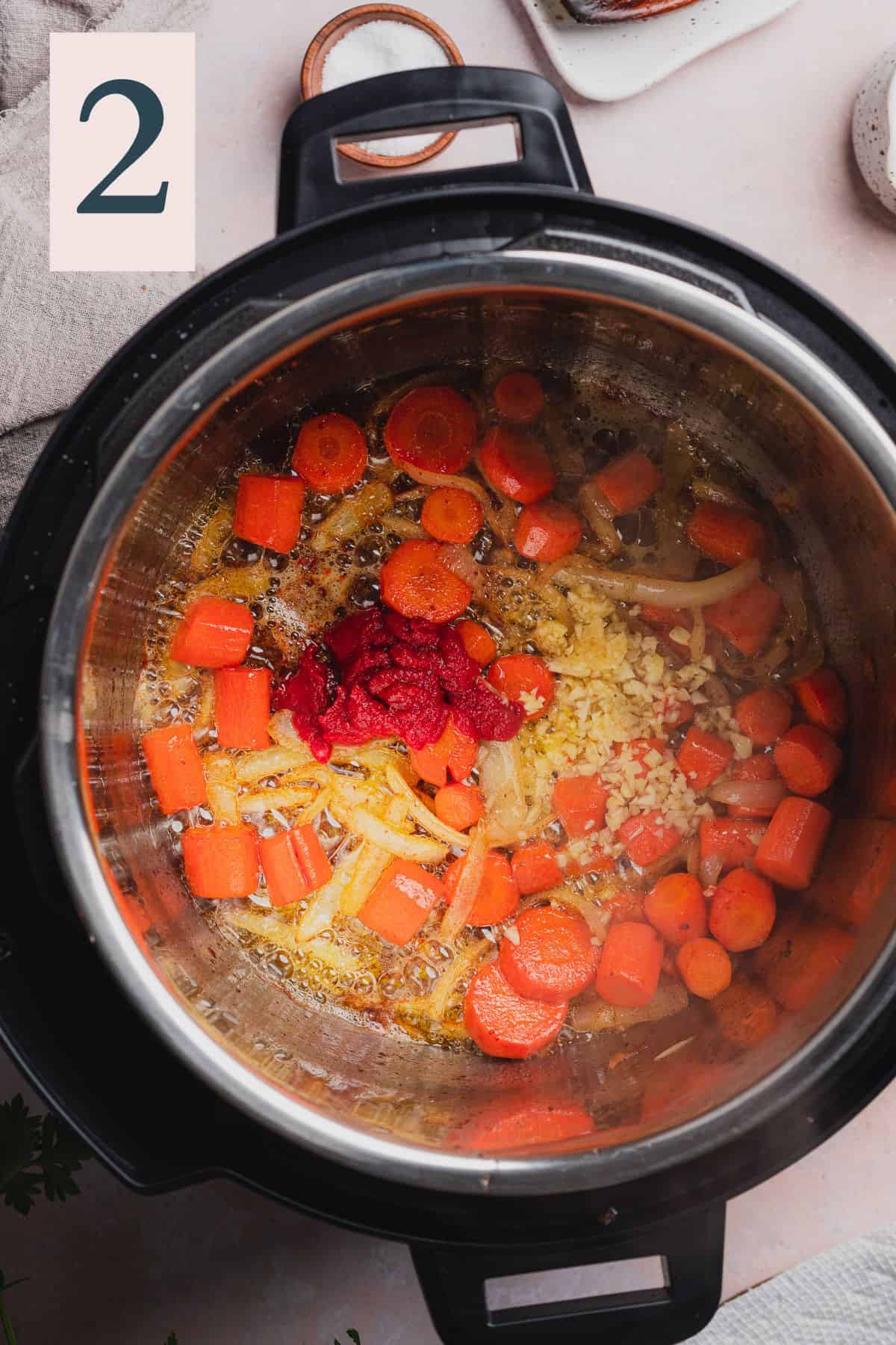 cooked onions and carrots in an instant pot with tomato paste and garlic.