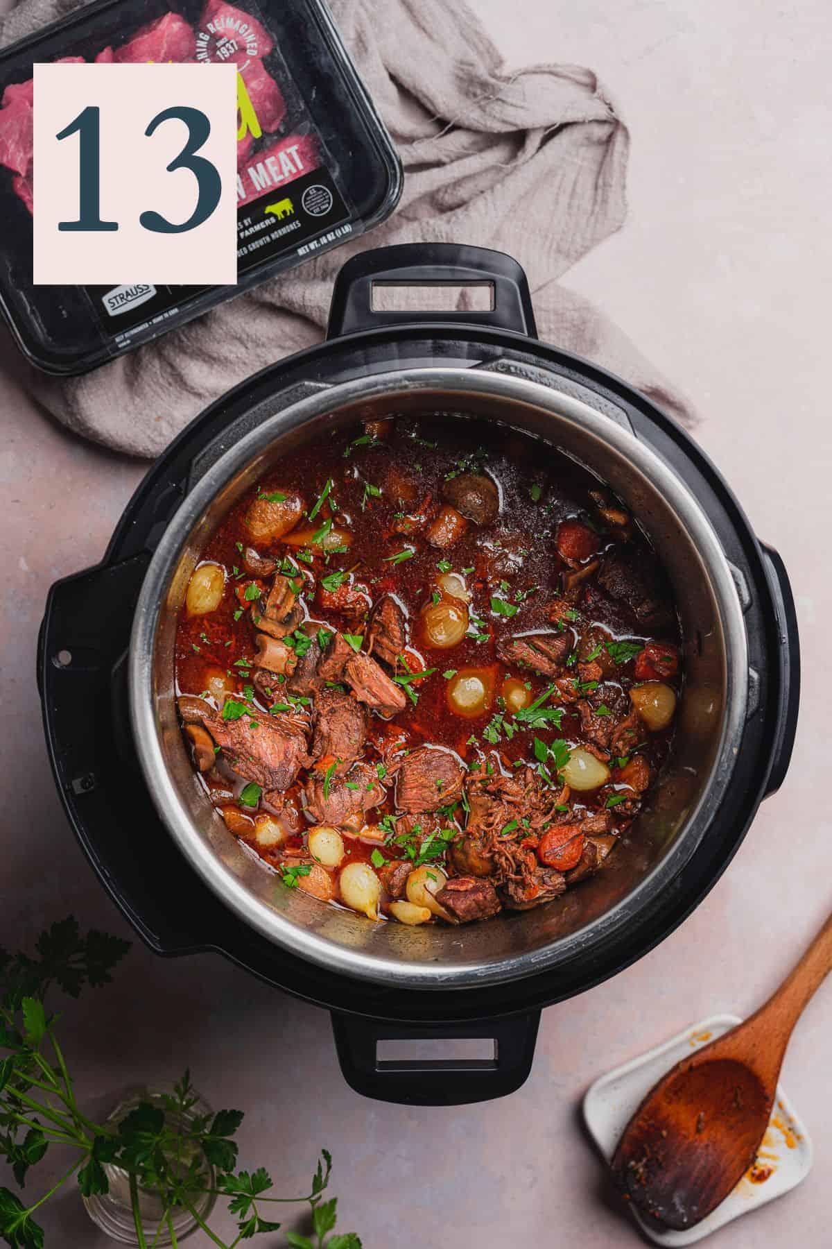 pressure cooker beef bourguignon with a package of grass rooted beef stew meat near by.