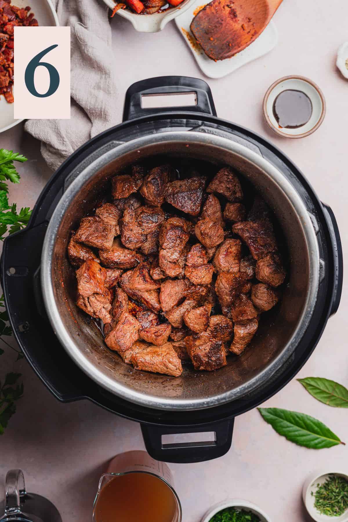 cooked and browned beef stew meat in an Instant pot.