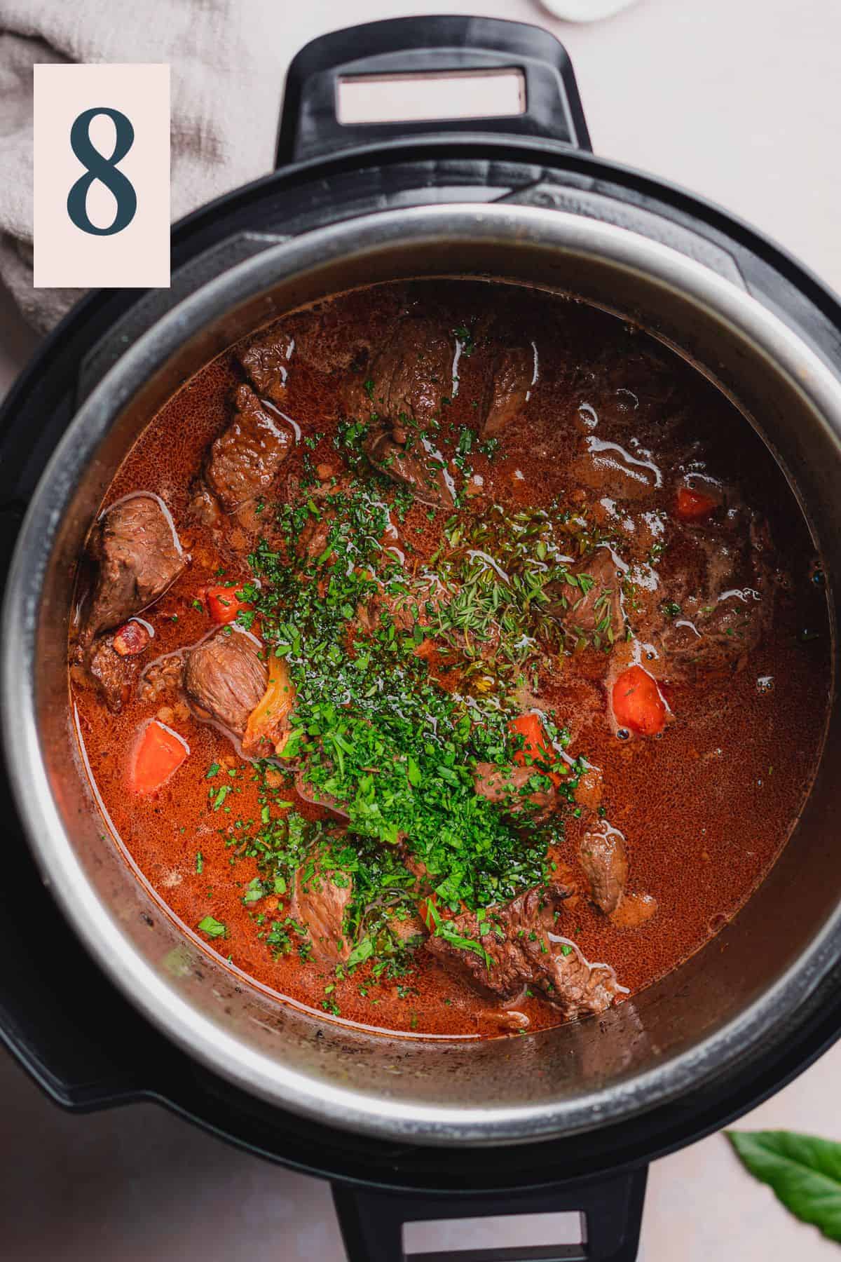 pressure cooker beef bourguignon with beef stock, red wine, parsley, and thyme in an Instant pot.