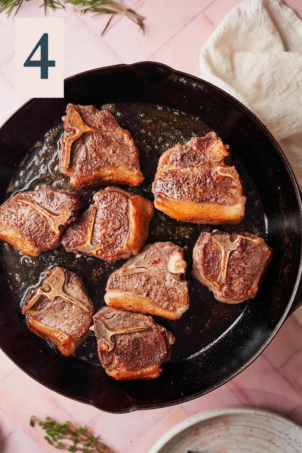 Cooked lamb chops in a large skillet. 