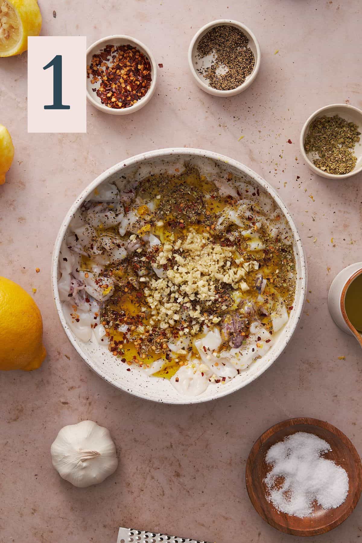 calamari in a large bowl with olive oil, garlic, seasonings, and lemon juice.