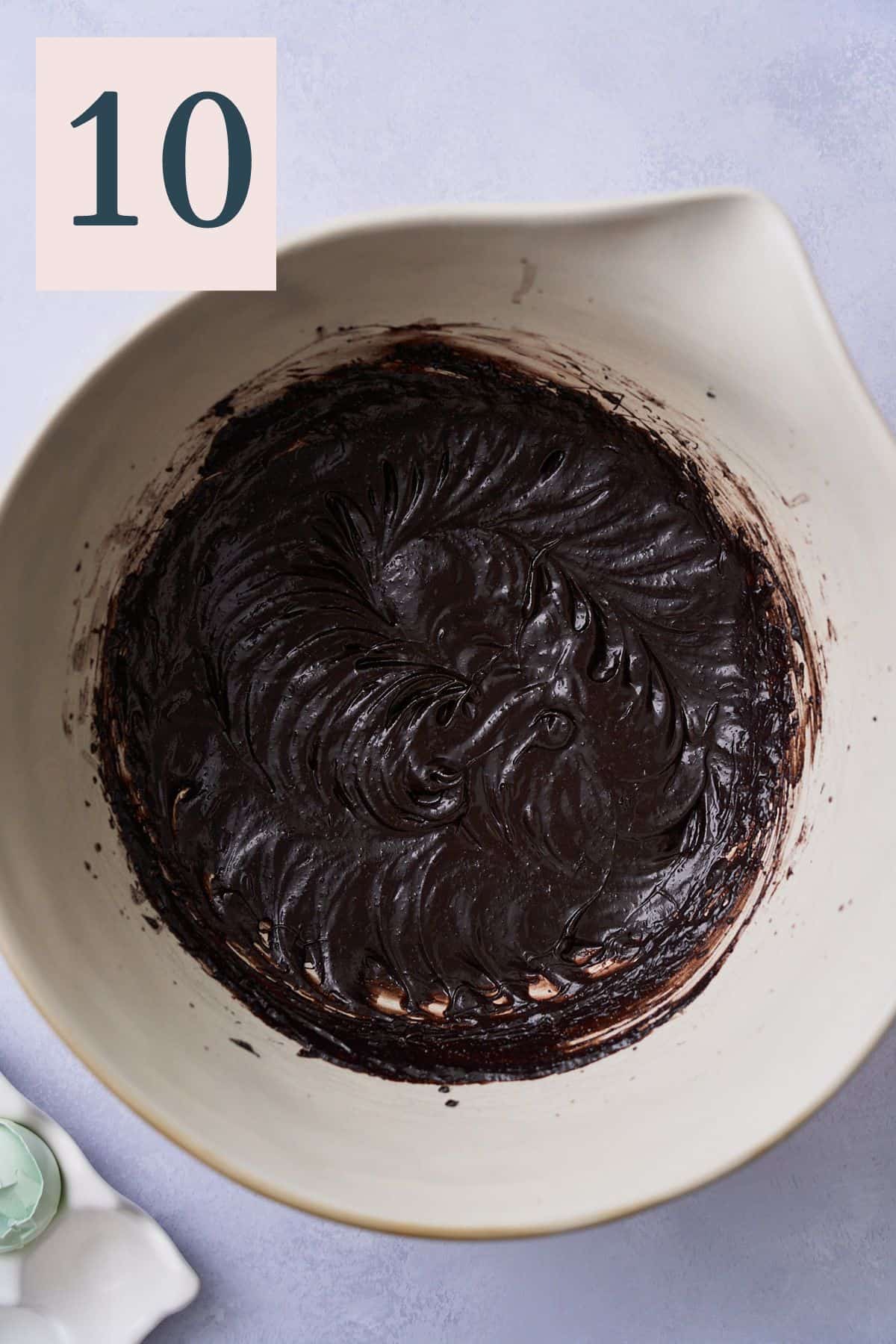 Smooth and creamy dark cocoa, butter, sugar, and egg mixture in a large bowl.