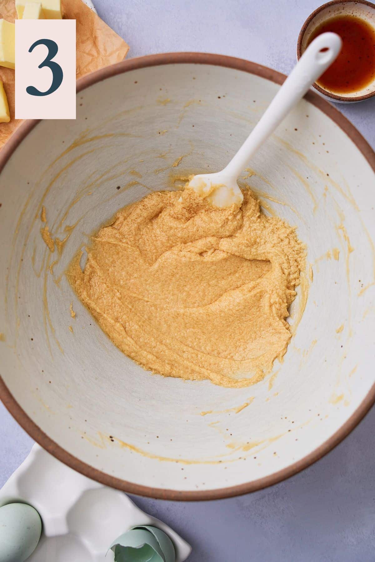 Smooth and creamy mixture of butter, eggs, sugar, and vanilla in a bowl to make cookie dough. 