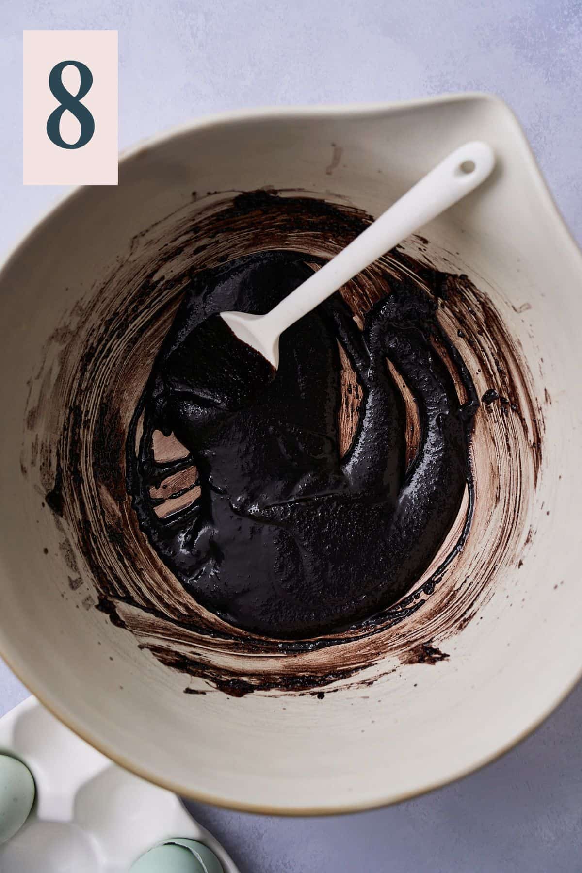 Dark cocoa powder, butter, and sugar mixed together in a bowl. 