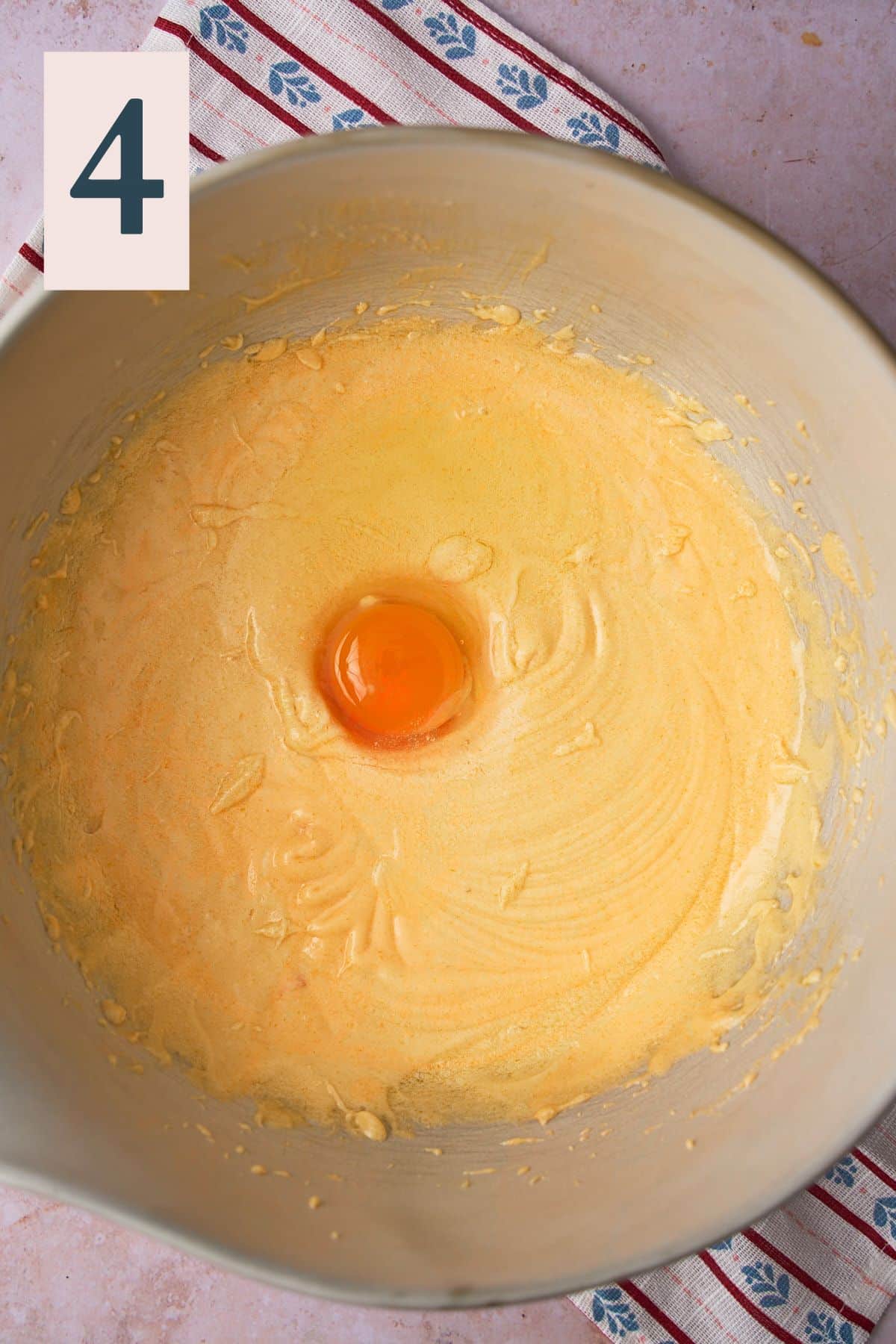Smooth and emulsified egg mixture in a large bowl with one whole egg added. 
