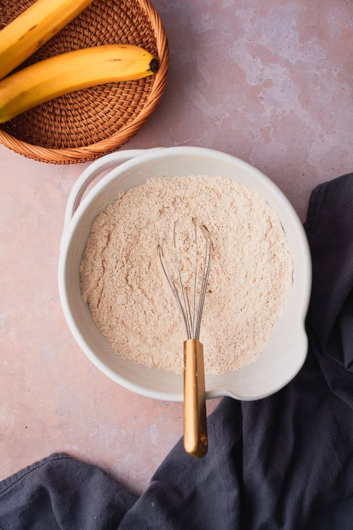 Bowl of dry ingredients with a bowl with a wicker basket with bananas inside.