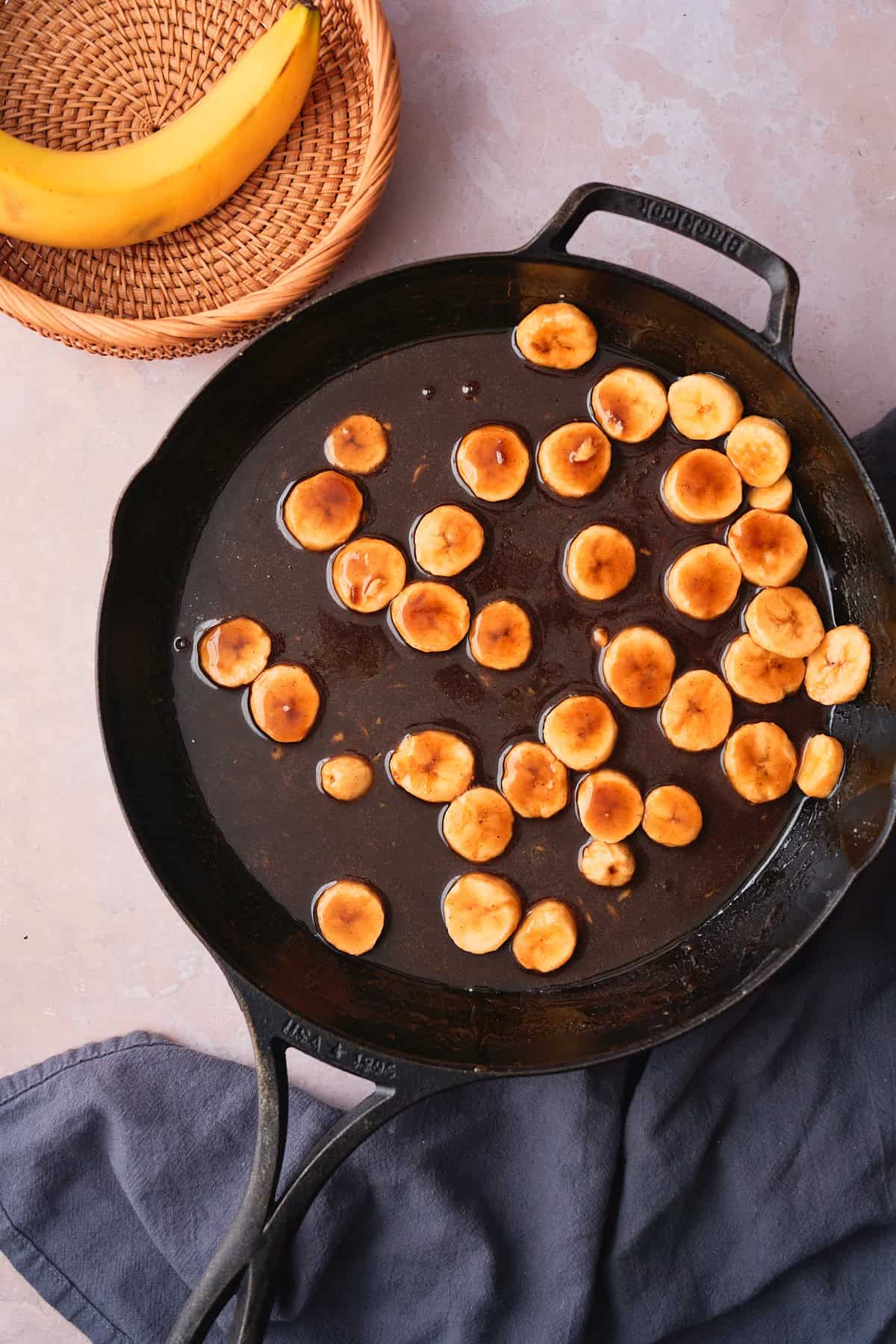 Cast iron skillet filled with rum caramel sauce and bananas to make a bananas foster like topping. 